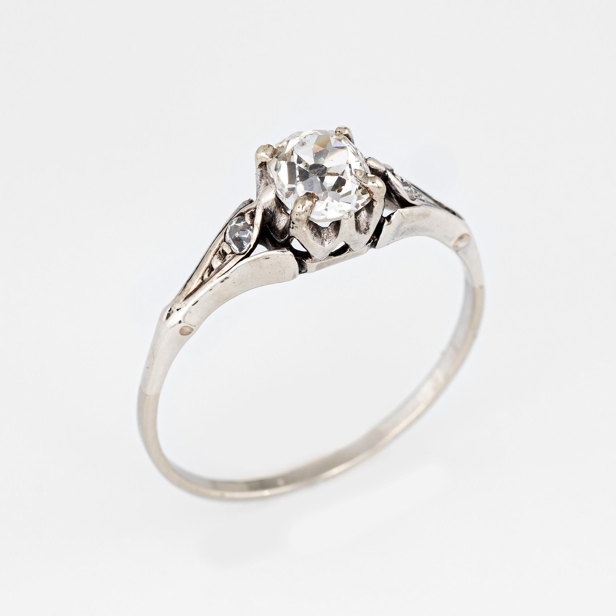 Eleganter und fein detaillierter Ring aus der Art-Déco-Ära (ca. 1920er bis 1930er Jahre), gefertigt aus 10 Karat Weißgold. 

Der zentral montierte, geschätzte 0,75 Karat schwere Diamant im Kissenschliff wird von zwei geschätzten 0,03 Karat schweren