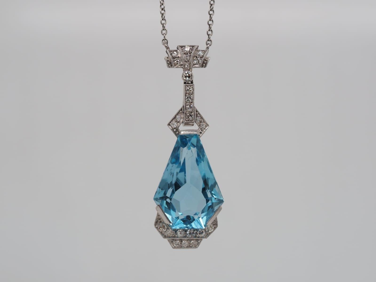 This True Vintage Art Deco Coffin Cut Aquamarine Dangle Necklace is a one of a kind. Its unique geometric shape is admirable and eye catching. The bold blue aquamarine center weighs 10.00 carats and measures 18.56 x 13.30 x 7.36 MM. The aquamarine