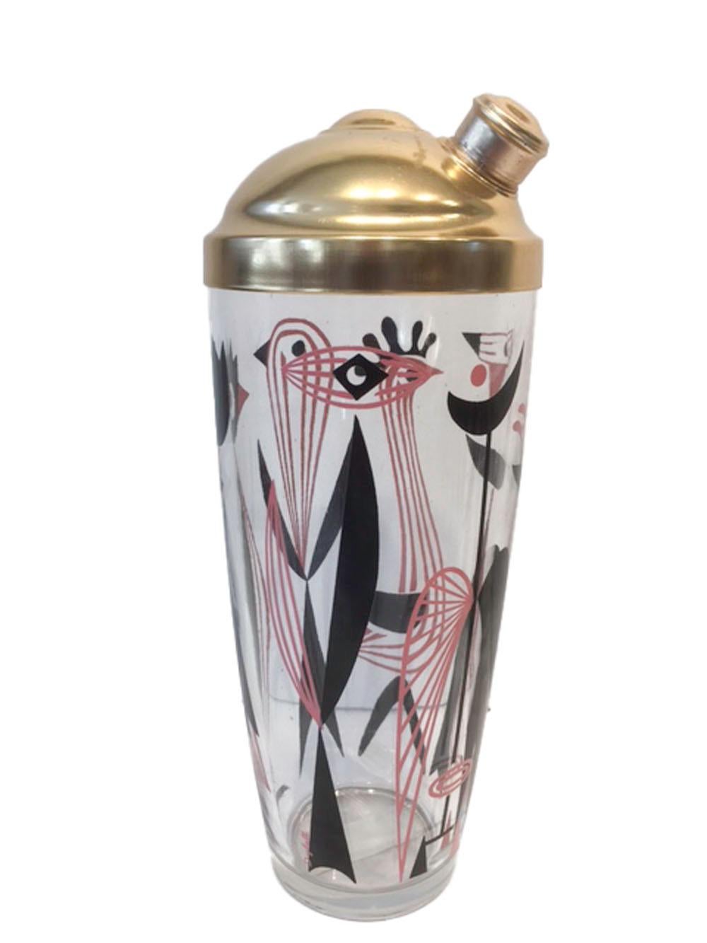 Vintage Dyball barware set consisting of a cocktail shaker with matte gold aluminum cover and four cocktail glasses along with six highball glasses - each piece decorated with stylized birds in pink and black enamel. All in excellent