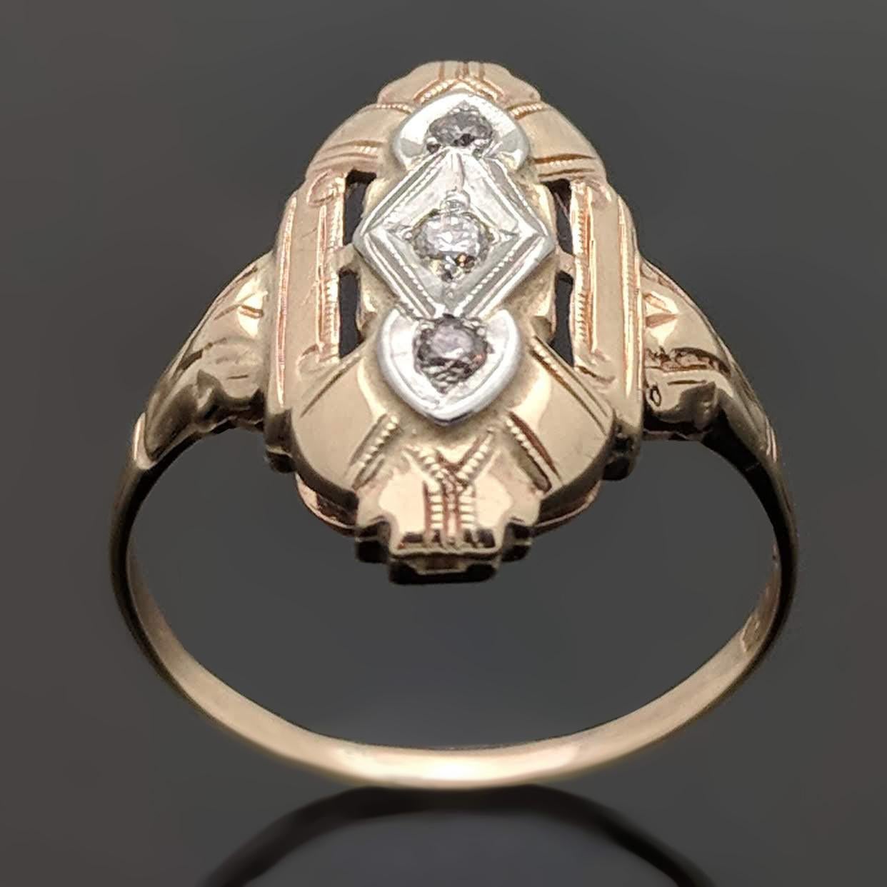 A vintage Art Deco 14kt yellow gold shield ring featuring 3 round brilliant-cut diamonds with an estimated weight of 0.03 ct. Estimated weight of gold is 1.25 gr. 

We will size it for you.

