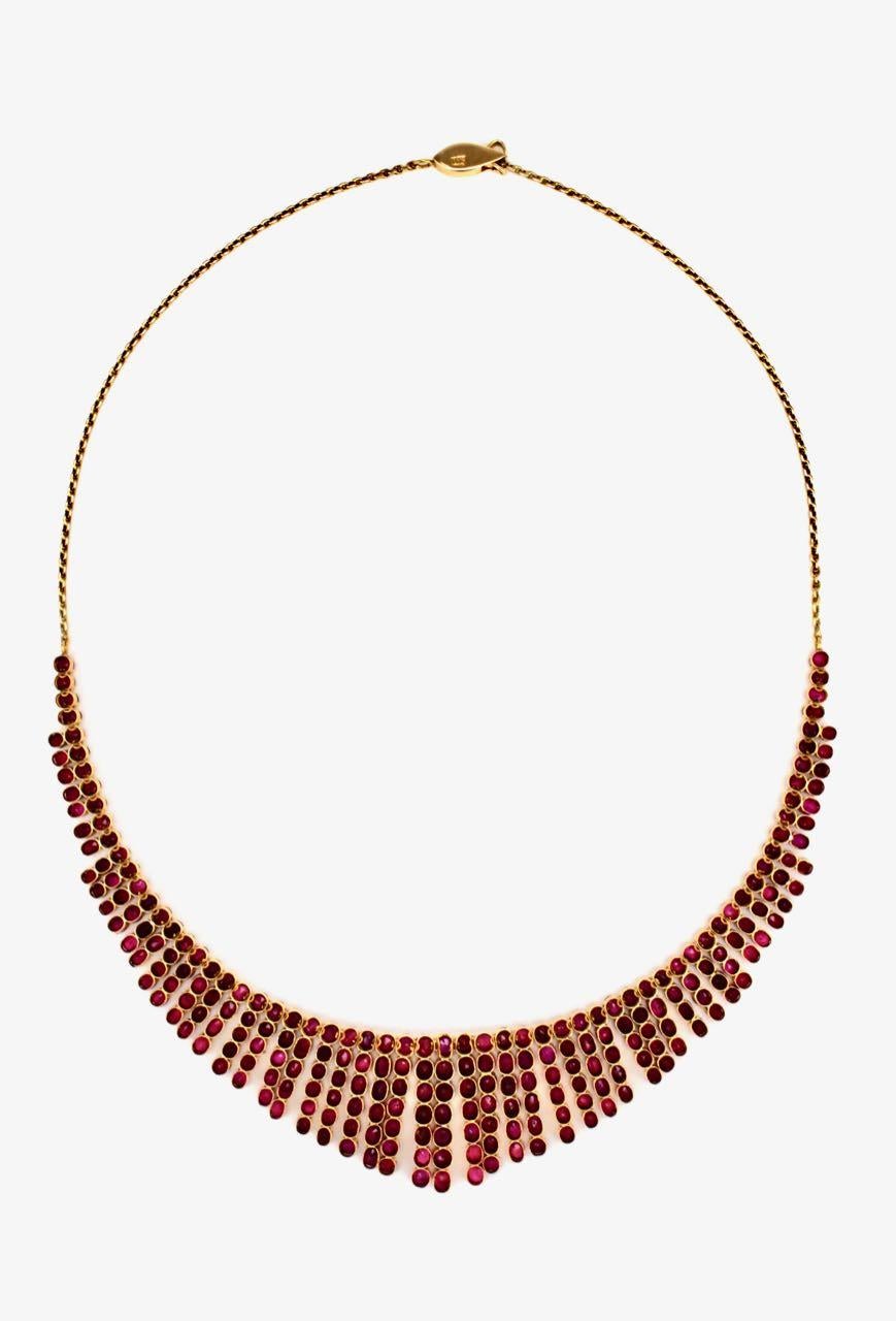 A spectacular necklace of 243 oval and round rubies of very good colour and good to medium clarity four claw set in 18k gold in a graduated fringe design with a chain back and opera hook clasp.  Rubies are often used as colour against other stones (