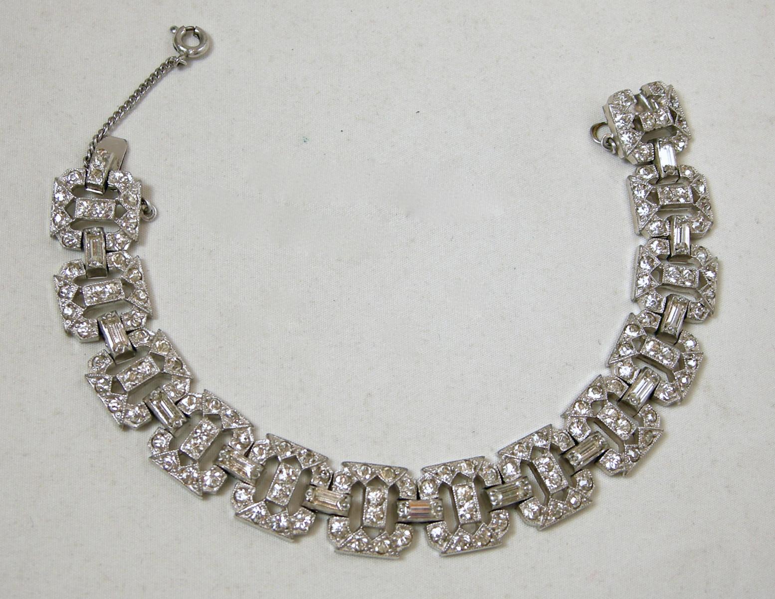 This vintage Art Deco 1930s bracelet has an open crystal link design in a rhodium silver tone setting.   In excellent condition, this bracelet measures 7-1/2” x 1/2” with a slide in clasp and safety chain.