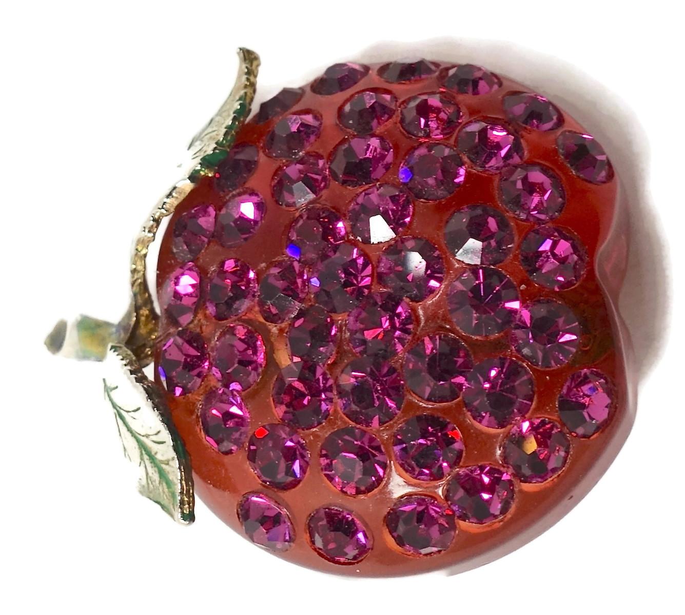 This vintage Art Deco1930s strawberry brooch is sometimes called “fruits of passion”. It is made with Lucite with pink crystals encrusted in the front and two green leaves on top.  In excellent condition, this highly collectible brooch measures