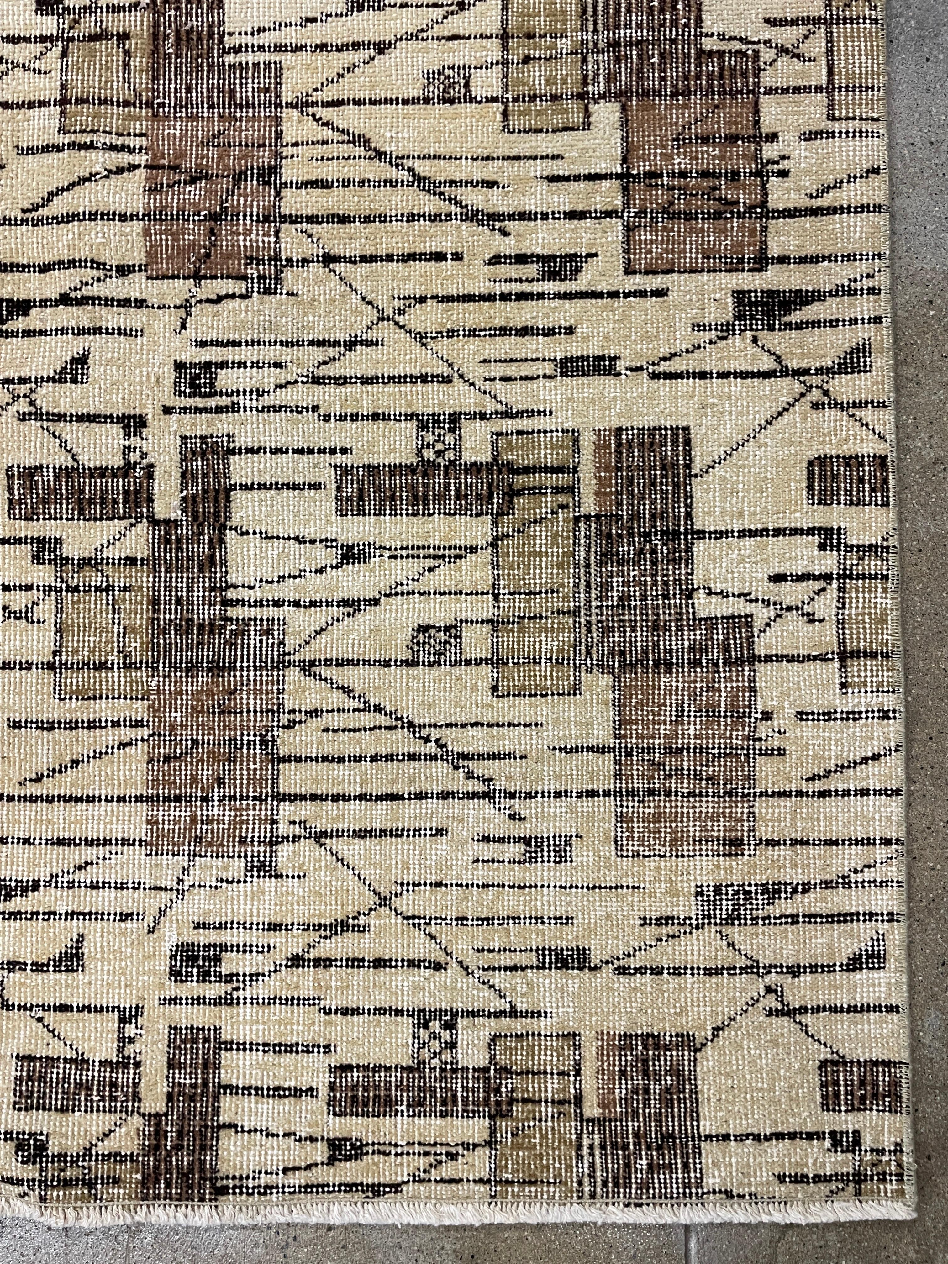 This Art Deco style rug features a bold all-over design of geometric and linear abstractions in cool dark brown against a field of light brown. This is a mid-century wool piece hand-made in the European part of Turkey and it’s clearly influenced by