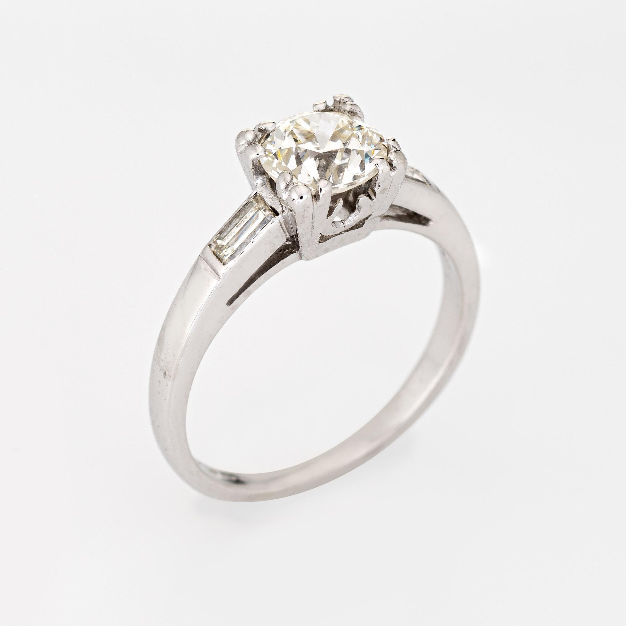 Elegant & finely detailed Art Deco era engagement ring (circa 1920s to 1930s) crafted in platinum. 

Centrally mounted estimated 1 carat old European cut diamond is accented with two estimated 0.04 carat rectangular cut diamonds. The total diamond