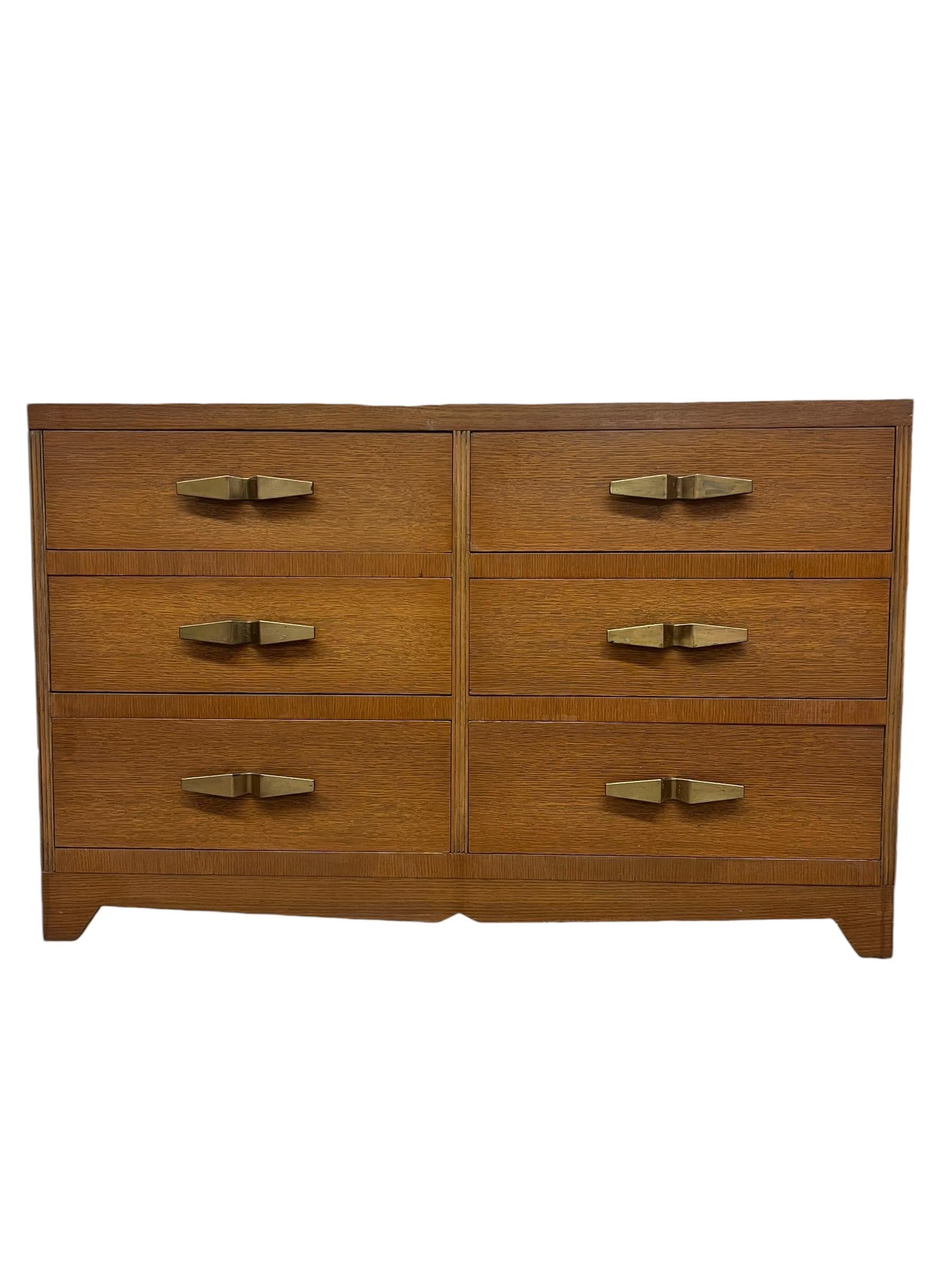 Art Deco lowboy dresser chest of drawers  in style of Robsjohn Gibbings for Widdicomb. This early representation is at the turning point between machine age and modern. The mahogany finish has aged to a rich honey color. Sleek and stately with just
