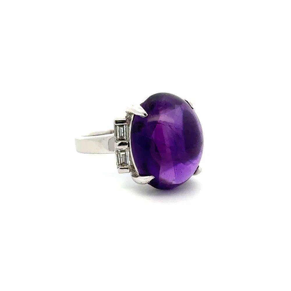 Simply Beautiful! Vintage Finely detailed Art Deco Amethyst and Baguette Diamond Platinum Solitaire Cocktail Ring. Centering a securely nestled 8.99 Carat Cabochon Amethyst accented by Baguette Diamonds, weighing approx. 0.45tcw. Hand crafted