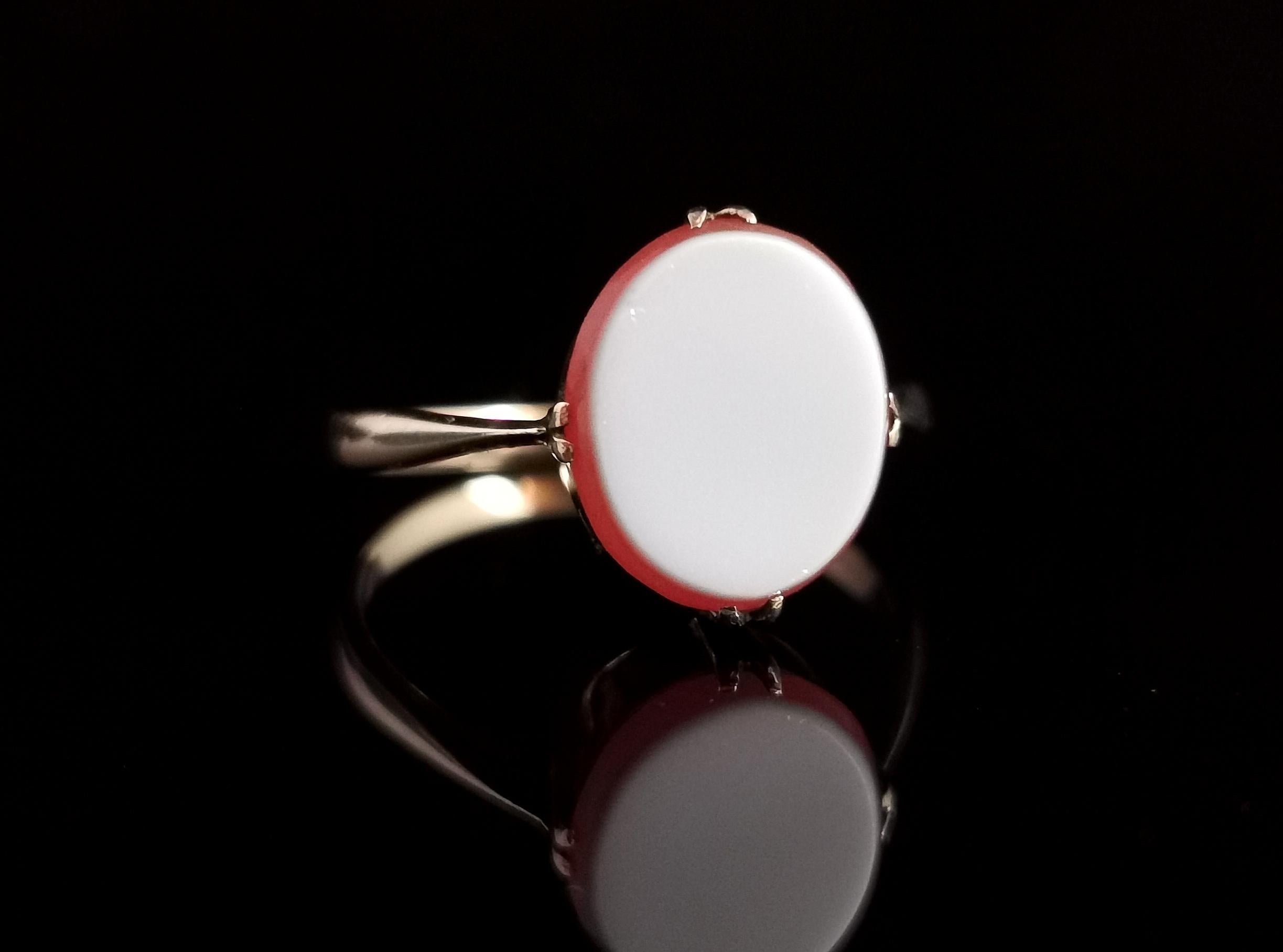 A sweet, Dainty vintage 9kt yellow gold, Sardonyx signet ring.

It is a delicate take on the signet ring with knife edge shoulders and a slim gold band.

The front is claw set with a lovely rich orangey red oval sardonyx with a white layer on