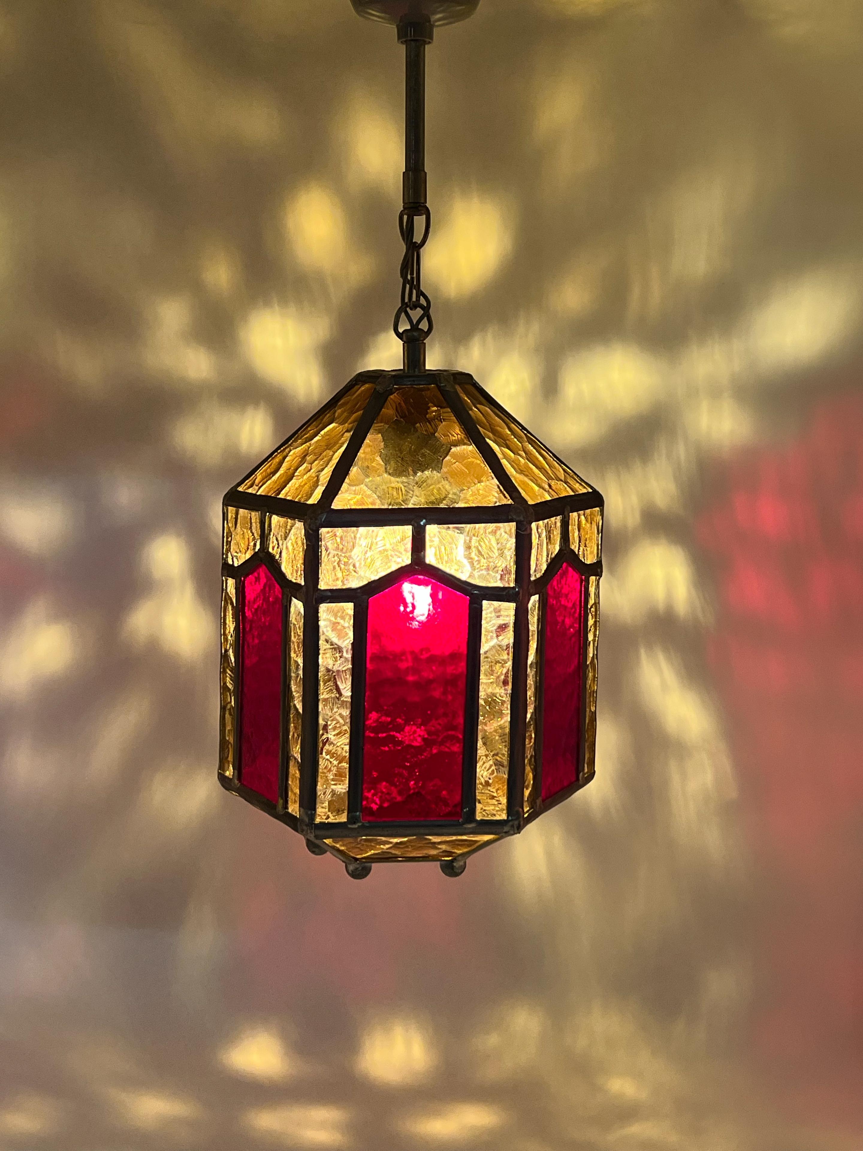 Step back in time with this beautiful Primitive Scandinavian/Swedish Design pendant lantern lamp, crafted in the 1940s/1950s. Handmade in Sweden, it features striking leaded amber and red glass with geometric patterns, embodying the elegance of ART