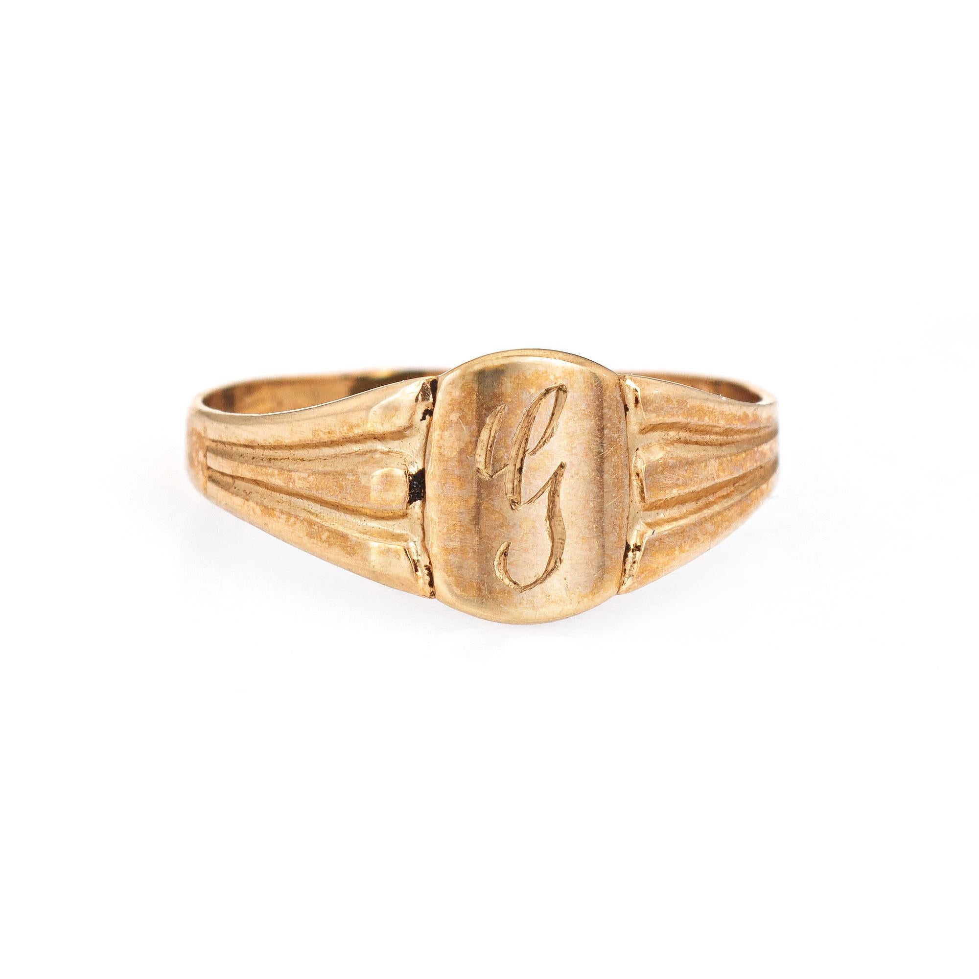 Finely detailed vintage Art Deco baby ring (circa 1920s to 1930s) crafted in 10k yellow gold. 

The sweet Art Deco era baby signet ring is engraved with the letter 'G' in old cursive font. The side shoulders feature column detail. The petite ring is