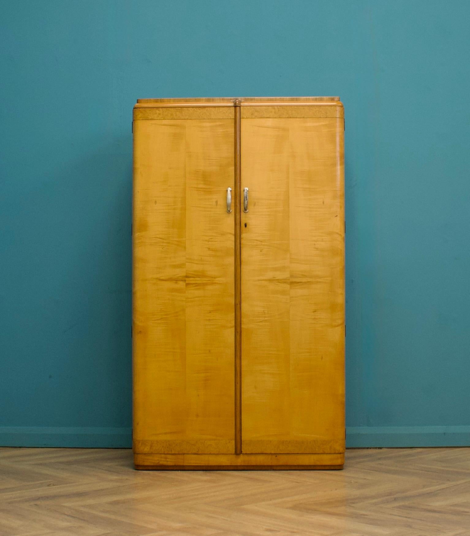 A vintage birch and walnut Art Deco compactum fitted wardrobe, circa 1930s.

Inside, beautifully fitted out with a pull-out clothes and shoe rail, shelves, drawers, and a compartment.

The matching three-door wardrobe and bed frame are available to