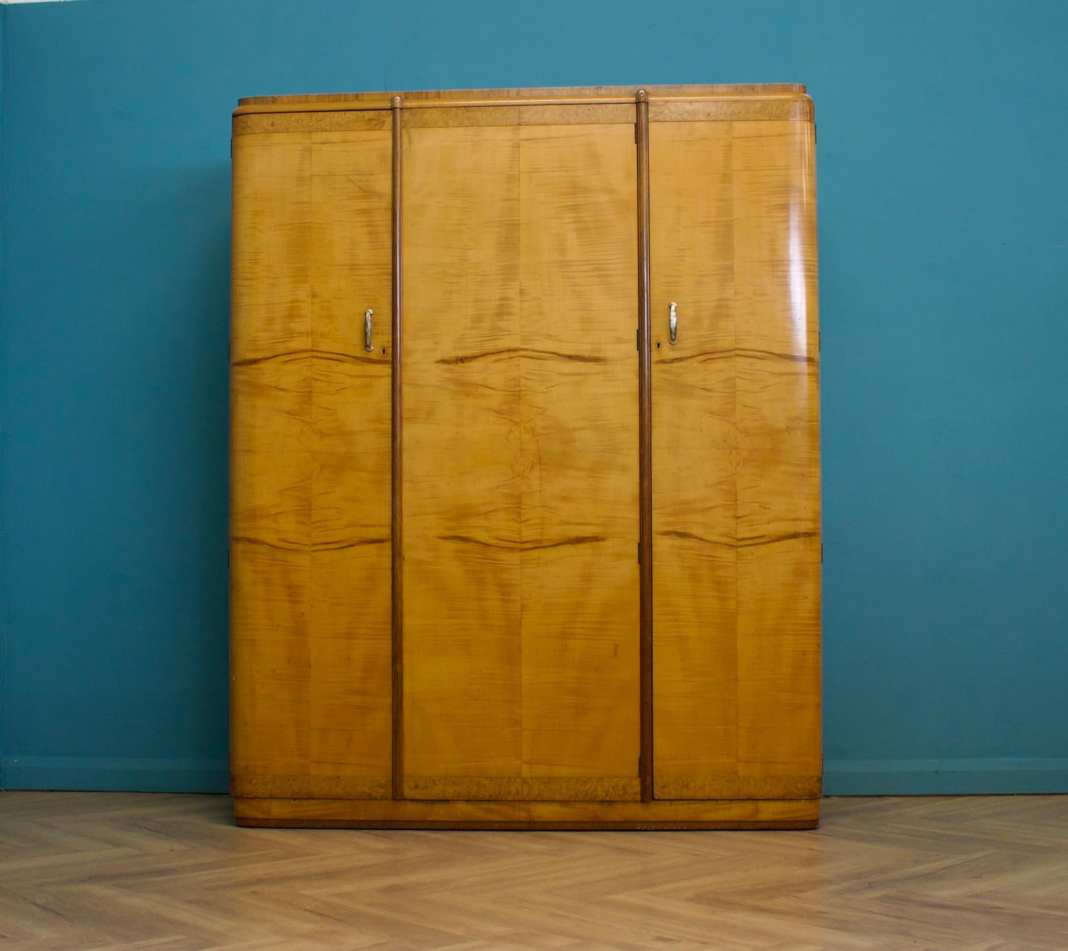 A vintage birch and walnut Art Deco triple door wardrobe, circa 1930s.


Inside, beautifully fitted out with a a clothes, shelves and drawers.


The matching compactum wardrobe and bed frame are available to buy separately.