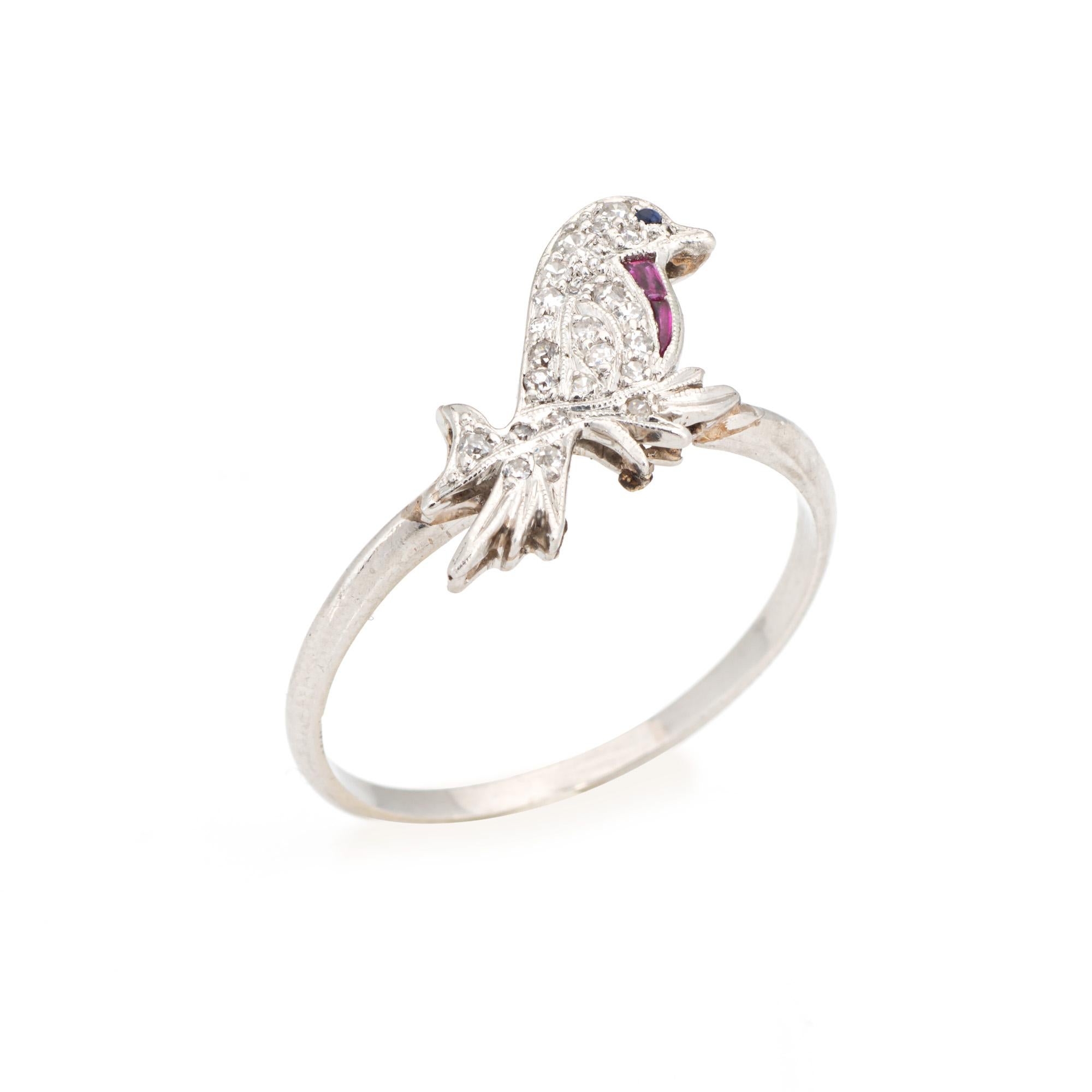 Originally an antique Art Deco era stick pin (circa 1920s to 1930s), the diamond ring is crafted in platinum.

21 diamonds total an estimated 0.10 carats (estimated at H-I color and SI1-I1 clarity). One 1mm sapphire (lab) is set into the eye. Two