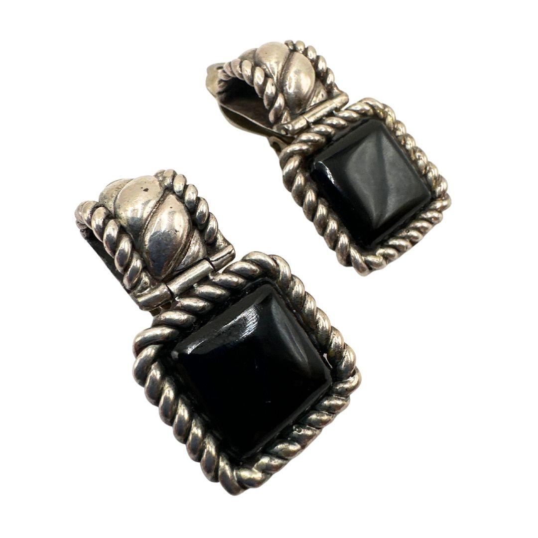 Earring Length:: 1.48″

Bin Code: A6 / P20

Add a touch of vintage glamour to your ensemble with these exquisite black glass and silver clip-on fashion earrings. Crafted with meticulous attention to detail, these earrings capture the essence of