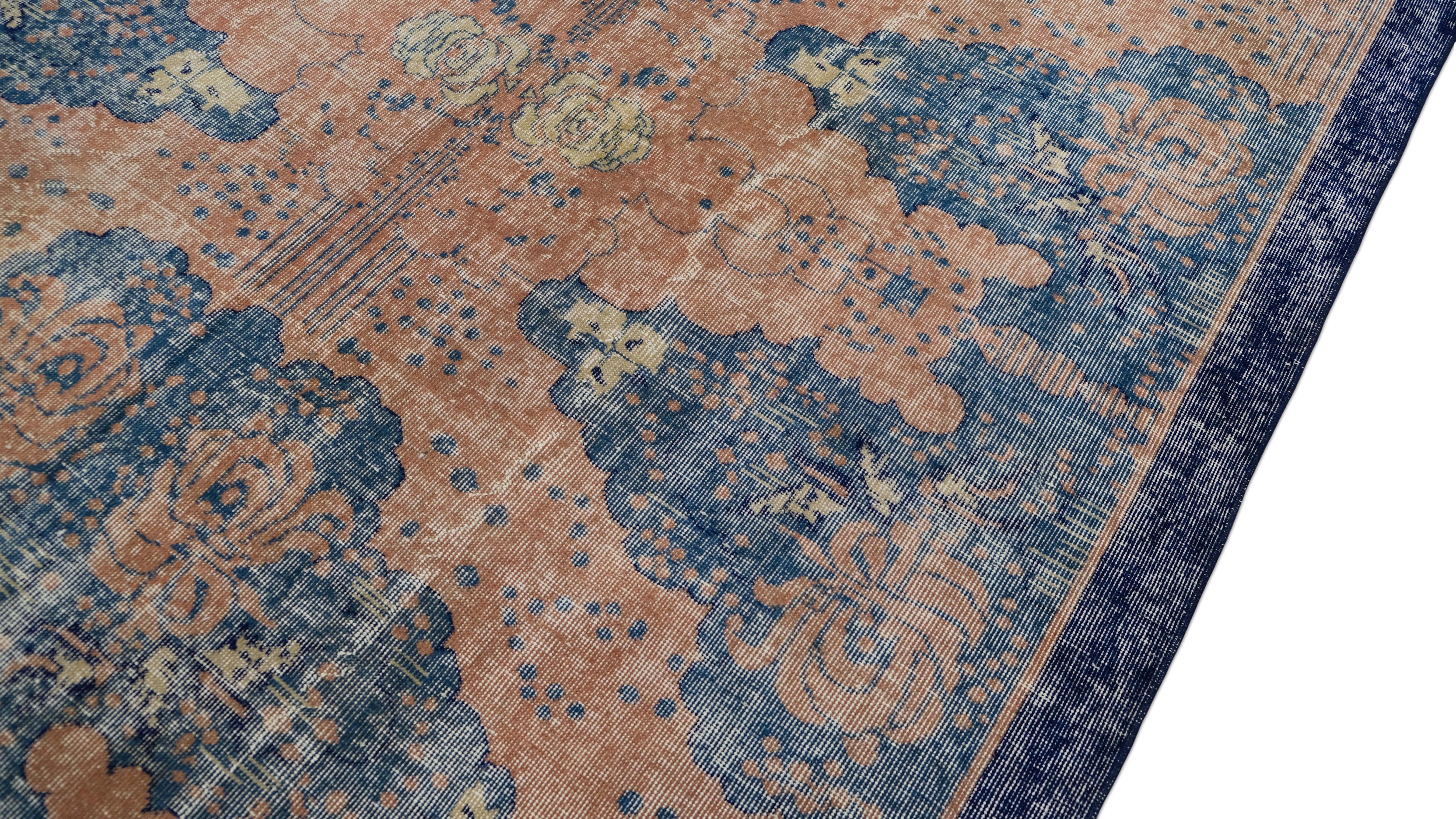 This hand-knotted  rug is a masterpiece of timeless artistry, featuring an elegant fusion of blues, and muted coral tones. The intricate floral and cloud-like motifs create a striking yet harmonious pattern, enriched by a beautifully distressed