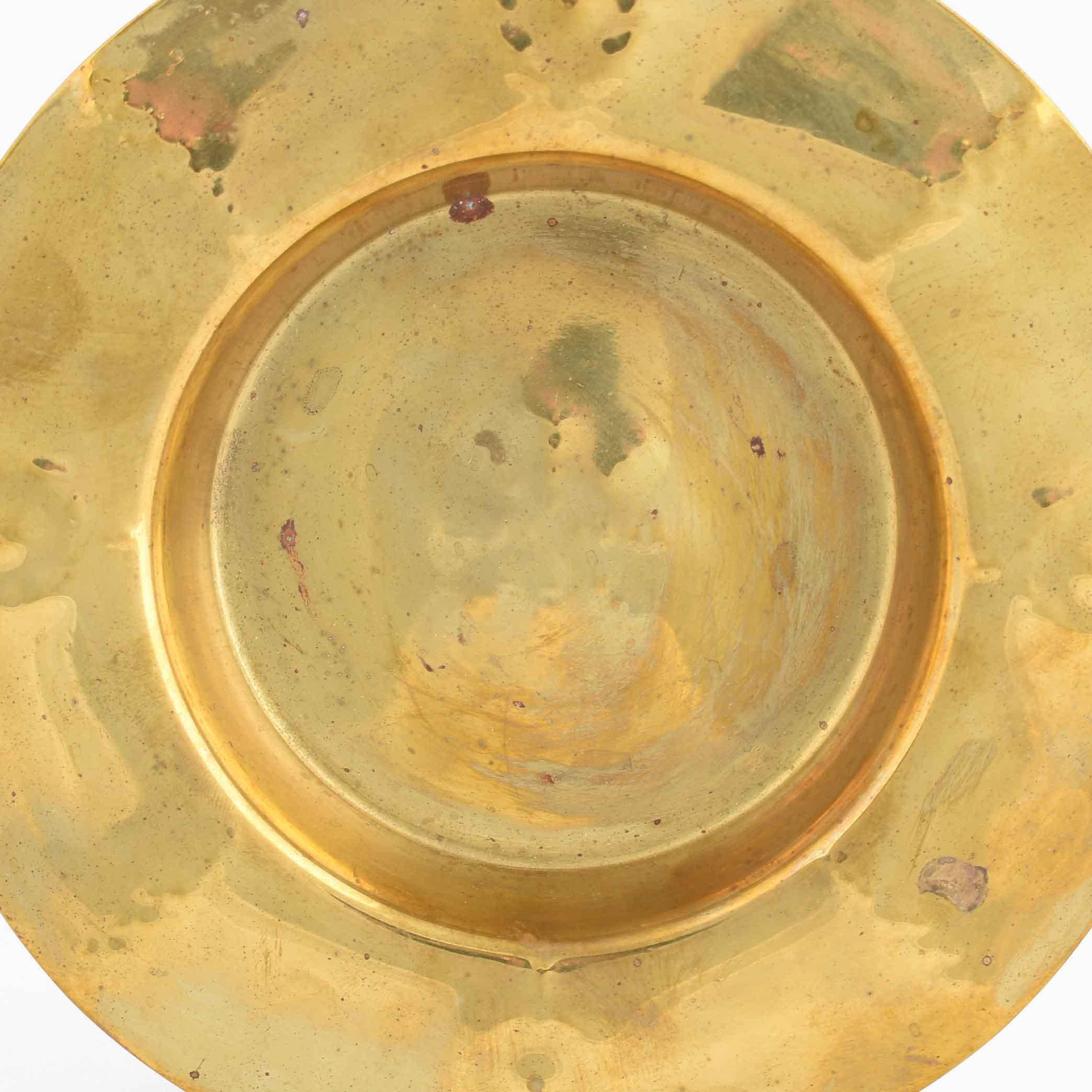 Art Deco brass plate is an original decorative artwork realized in the 1930s.

Original brass decorative object.

Fine conditions: vintage signs of aging are present.

Beautiful decorative plate realized with an hammered decoration on a on