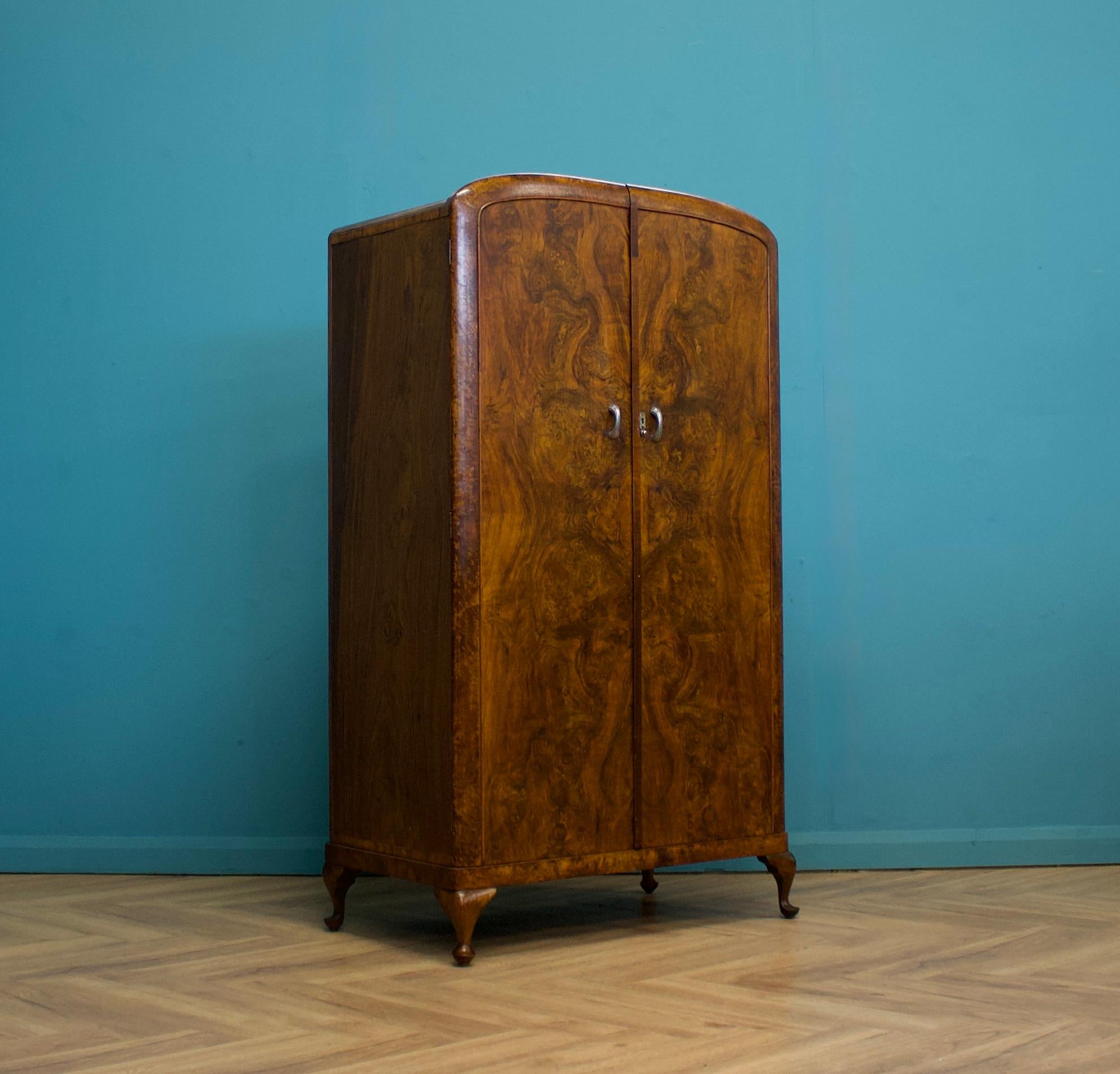 Ein kompakter Kleiderschrank aus Wurzelnussholz im Art-Deco-Stil der 1930er Jahre
Ausgestattet mit einer Kleider- und Schuhstange, Regalen und Schubladen