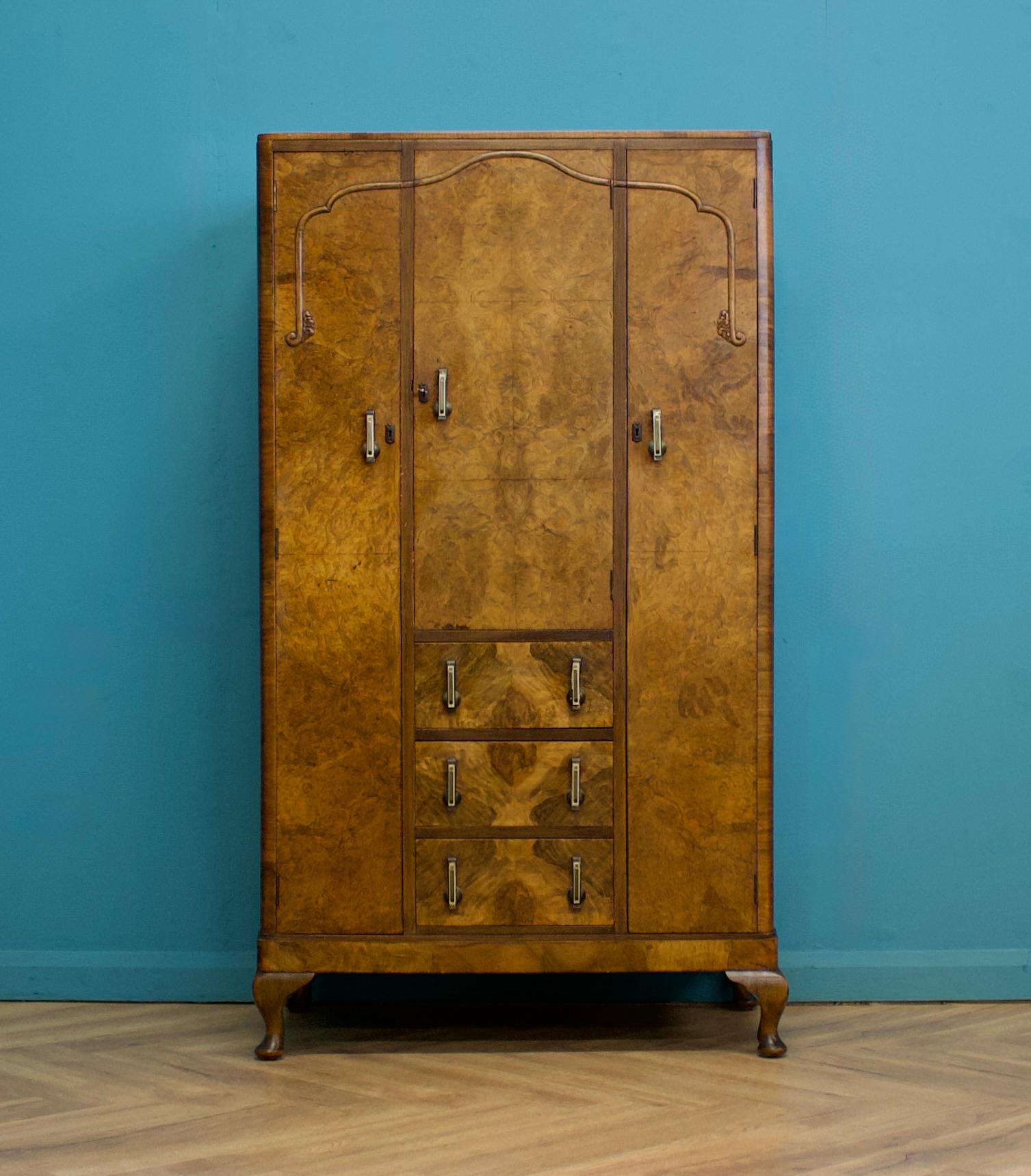 An Art Deco 1930's burr walnut compact wardrobe.
Featuring two hanging compartments, a compartment with shelves and three drawers