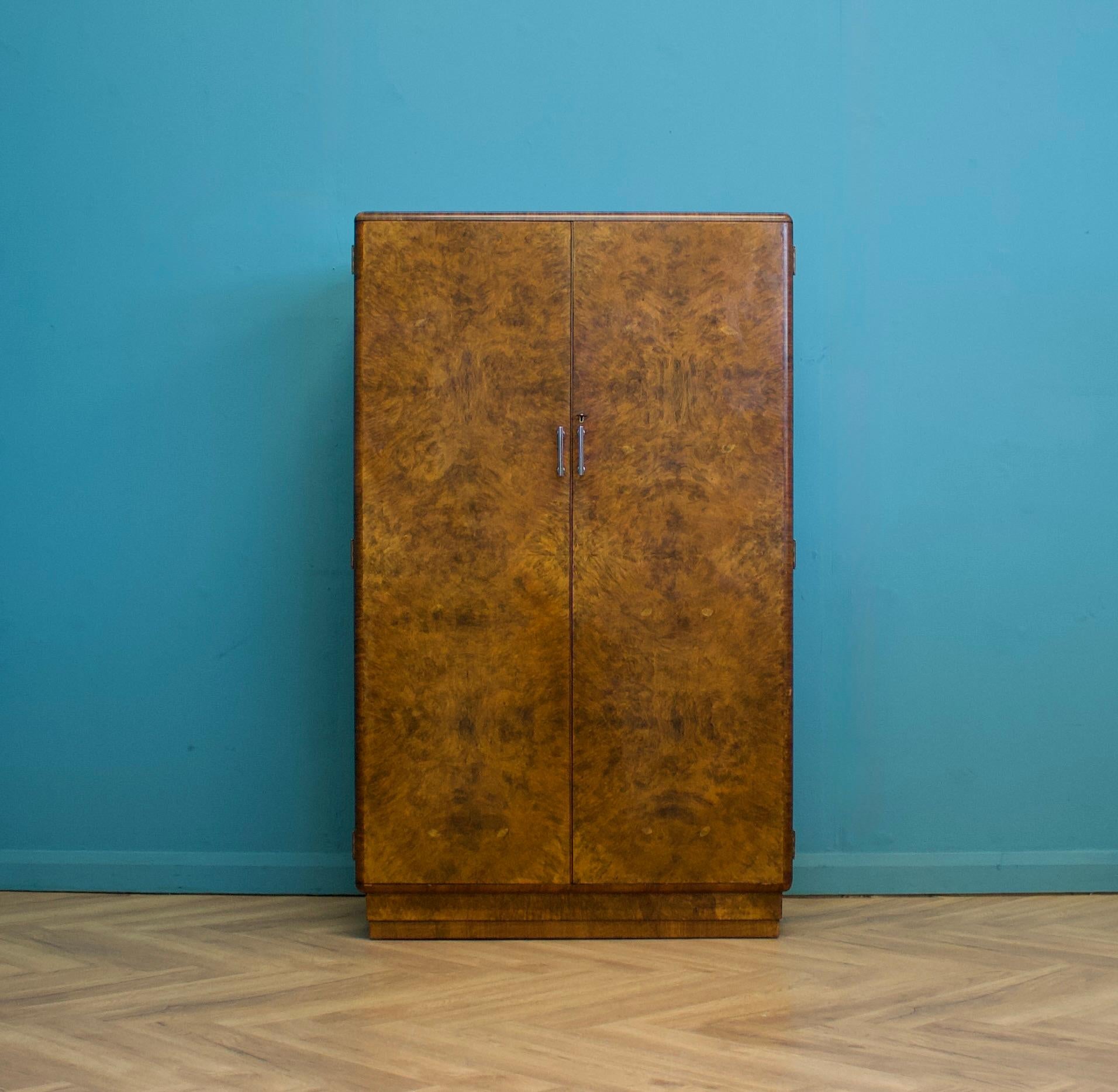 Eine schöne Qualität Art Deco 1930's Wurzelholz kompakten Kleiderschrank von Heals.
Ausgestattet mit einer Kleider- und Schuhstange, Kleiderhaken, Einlegeböden und Schubladen mit Metallgriffen.

Die Außengriffe sind ebenfalls aus Metall und das