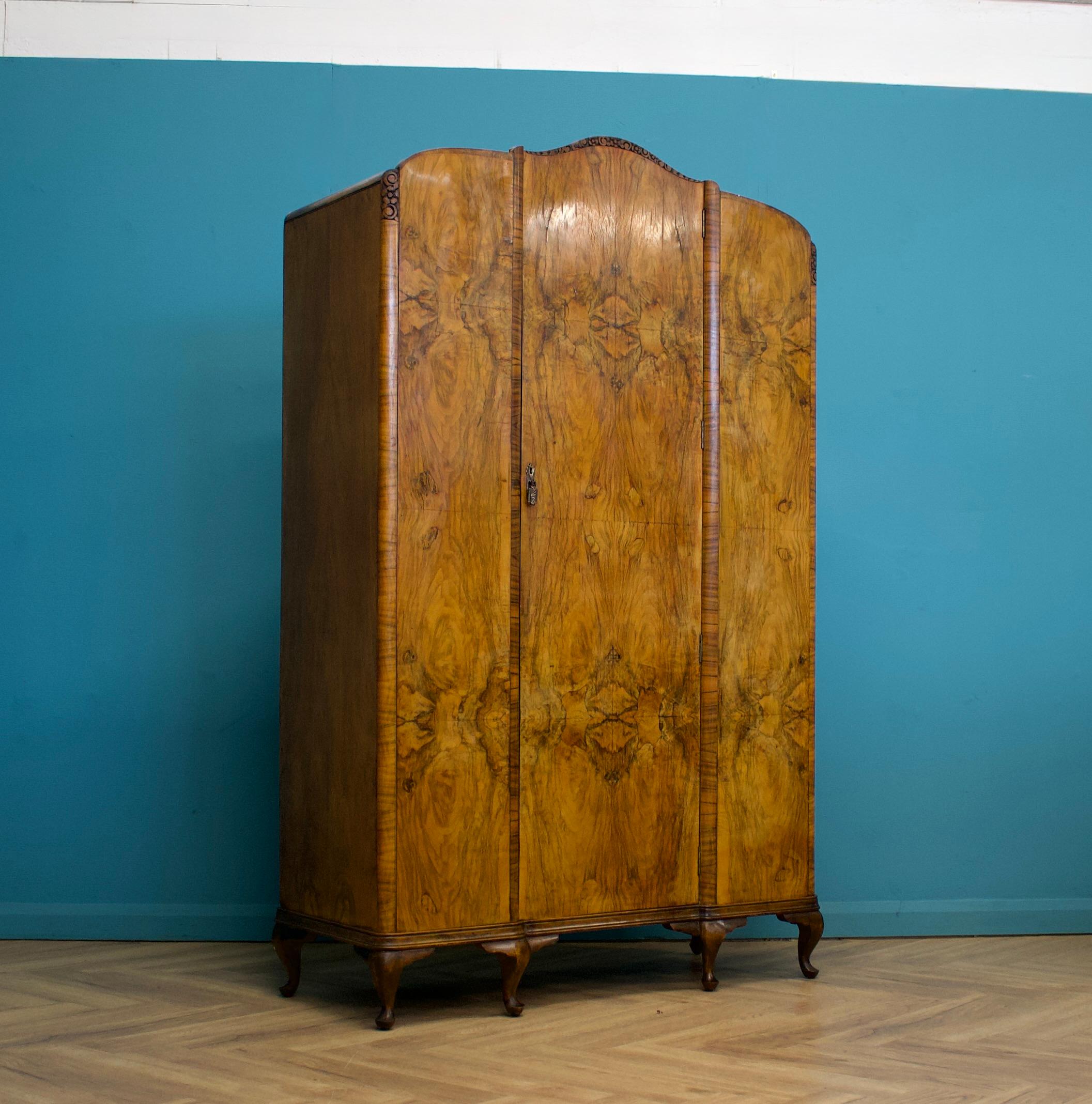 An impressive quality Art Deco burr walnut wardrobe, circa 1930s


Standing on Queen Anne style feet


Internally there's a shelf and two clothes rails 




The wardrobe does not lock, but the latch works - the handles are made from metal


There's