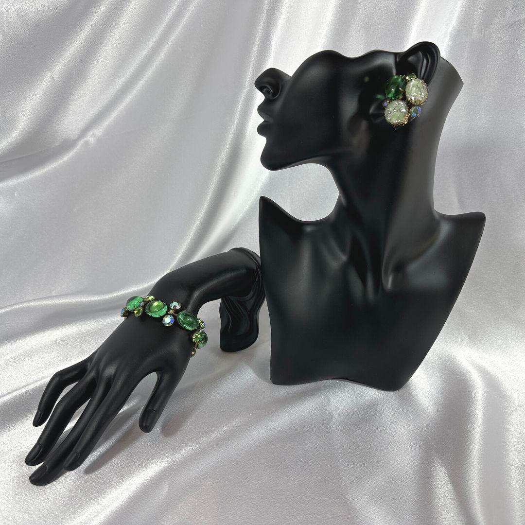 
Step into the timeless elegance of a Vintage Art Deco Cabochon Glass & Rhinestones Set, featuring a bracelet and earrings that encapsulate the allure of a bygone era. The bracelet, with a length of 7 inches, is a stunning piece that seamlessly