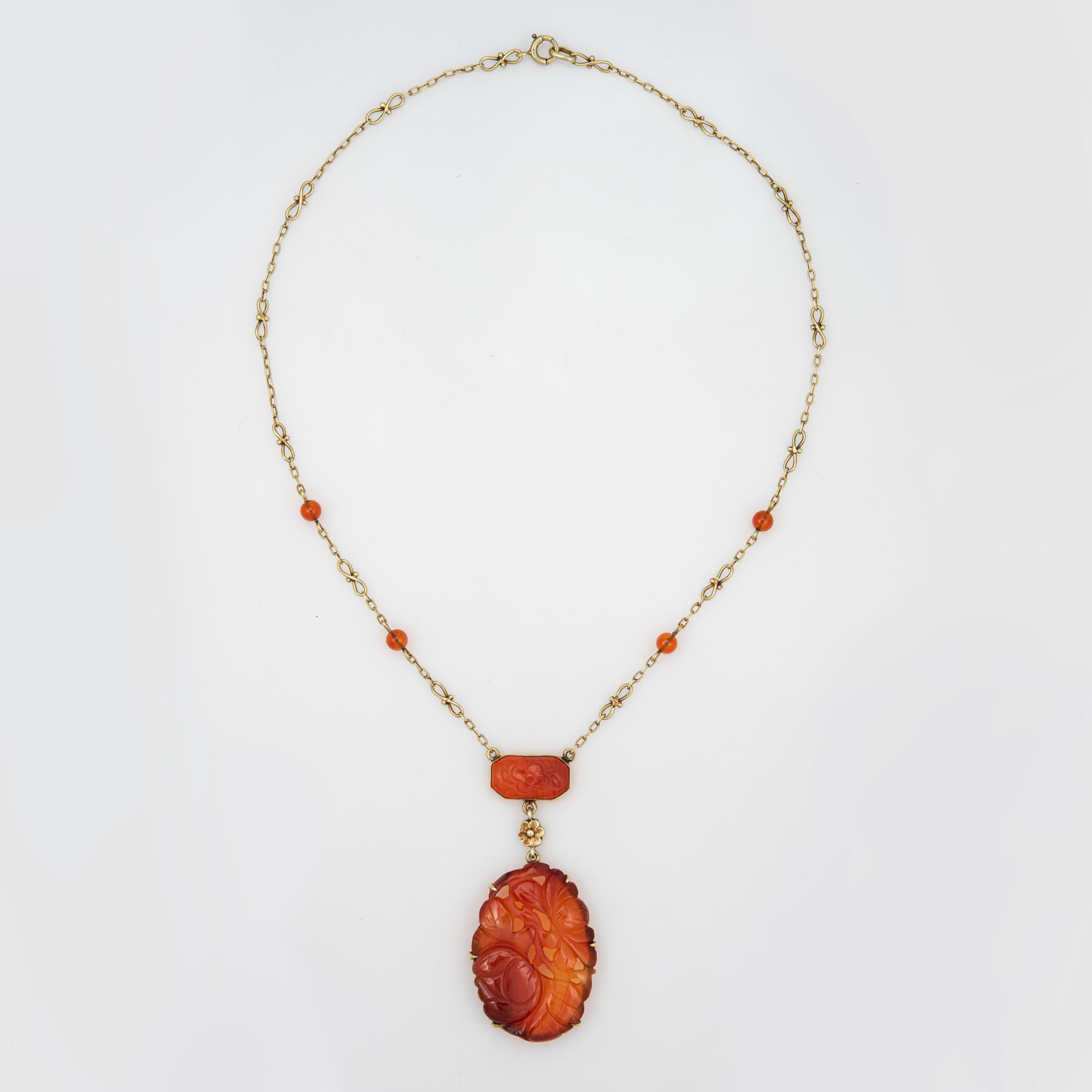 Finely detailed vintage Art Deco era carved carnelian necklace (circa 1920s to 1930s), crafted in 14 karat yellow gold.  

The larger carnelian drop measures 1 1/2 x 1 inch, with the smaller rectangular piece measuring 15mm x 9mm. Small 4.5mm beads
