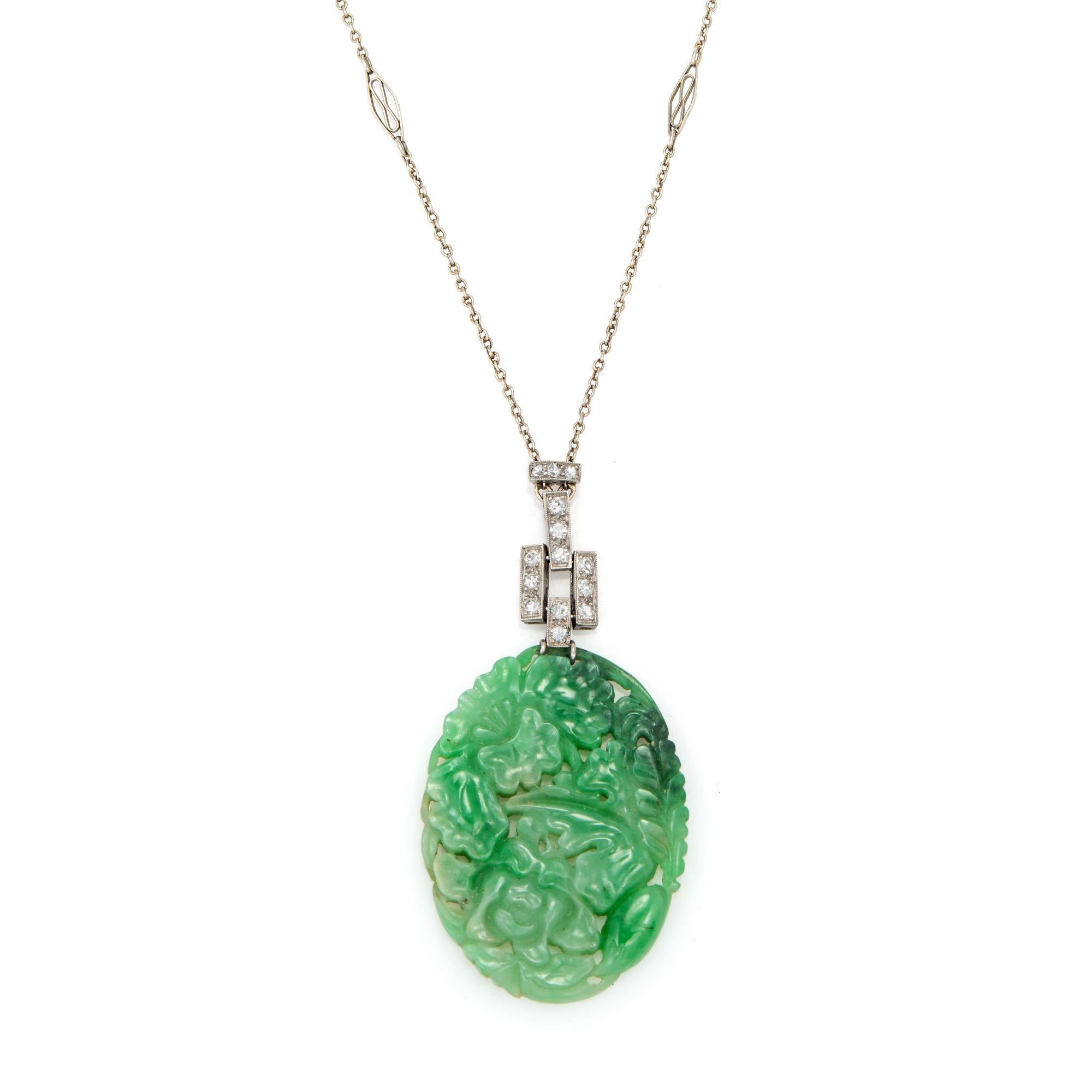 Finely detailed vintage Art Deco era carved jade & diamond necklace (circa 1920s to 1930s), crafted in 14 karat white gold & platinum.  

Carved jade measures 36.54mm x 27.5mm. 14 single cut diamonds total an estimated 0.10 carats (estimated at H-I