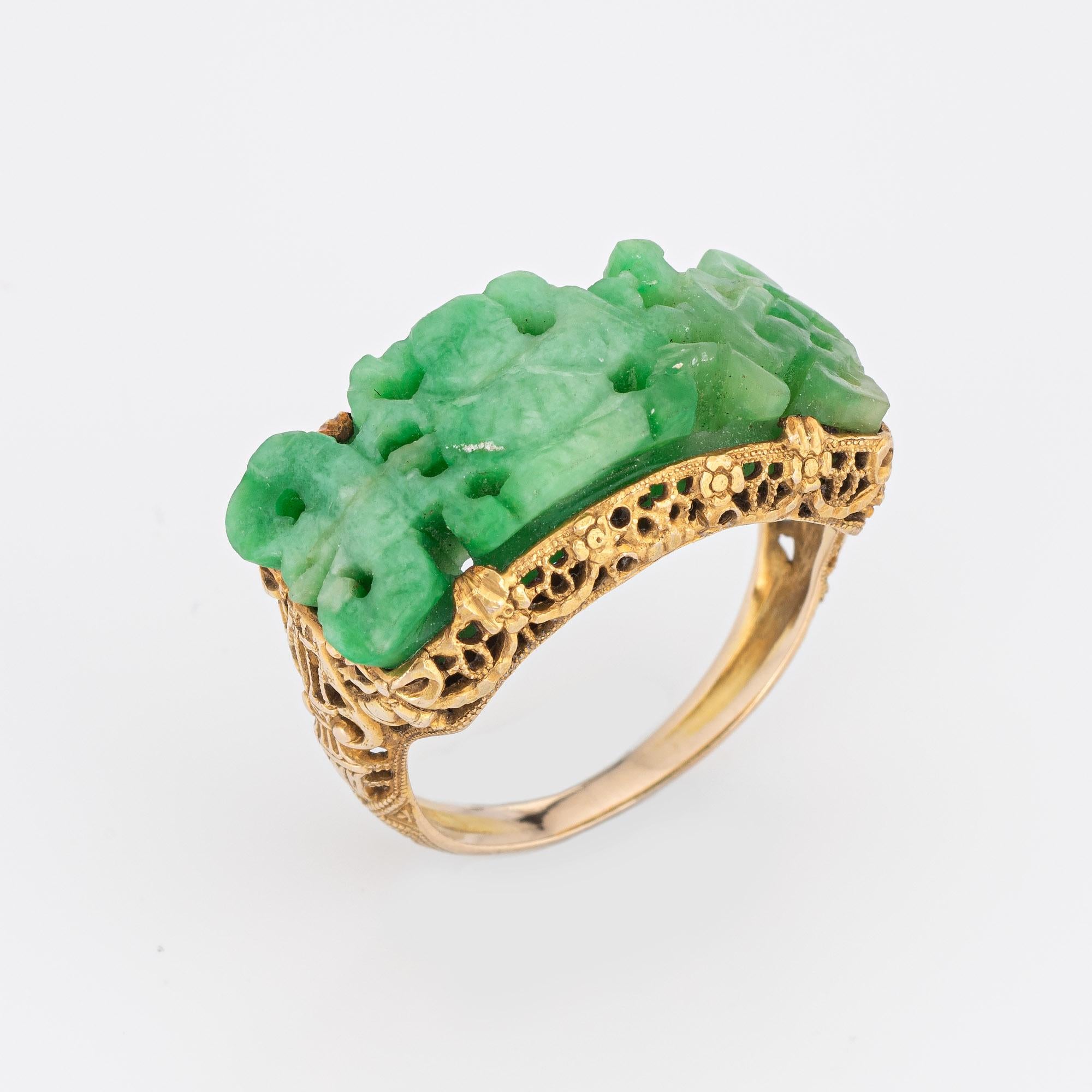 Finely detailed vintage Art Deco era carved jade ring (circa 1920s to 1930s) crafted in 14k yellow gold. 

Jade measures 24mm x 10mm.  

The finely detailed Art Deco ring captures the essence of the iconic era. The center set carved jade highlights