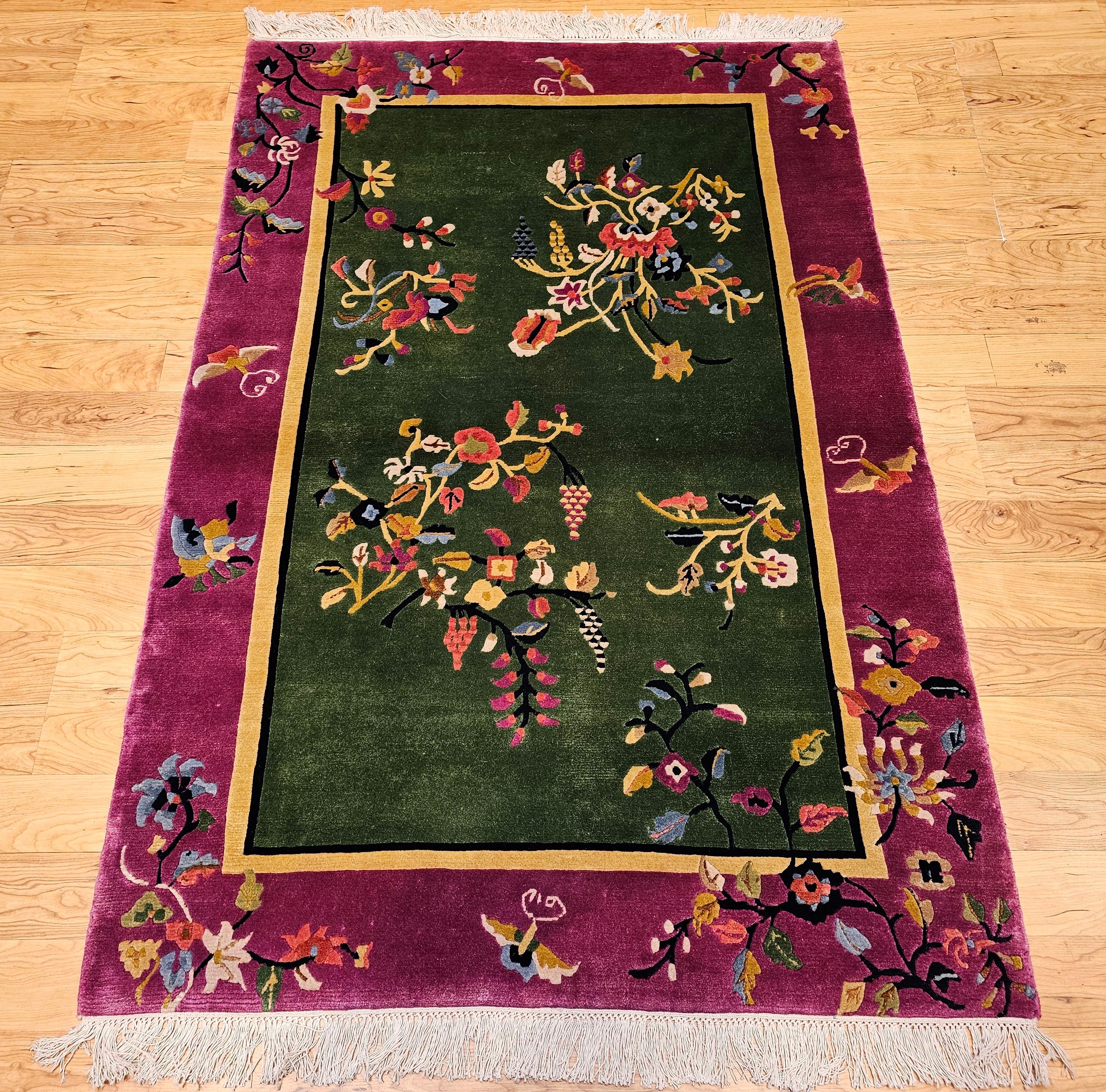 Dieser anmutige und auffällige chinesische Vintage-Teppich im Art-Déco-Stil zeichnet sich durch ein elegantes, florales Allover-Muster in einem weichen, salbeigrünen Feld aus, das von einer kühnen königspurpurnen Bordüre eingerahmt wird. Die
