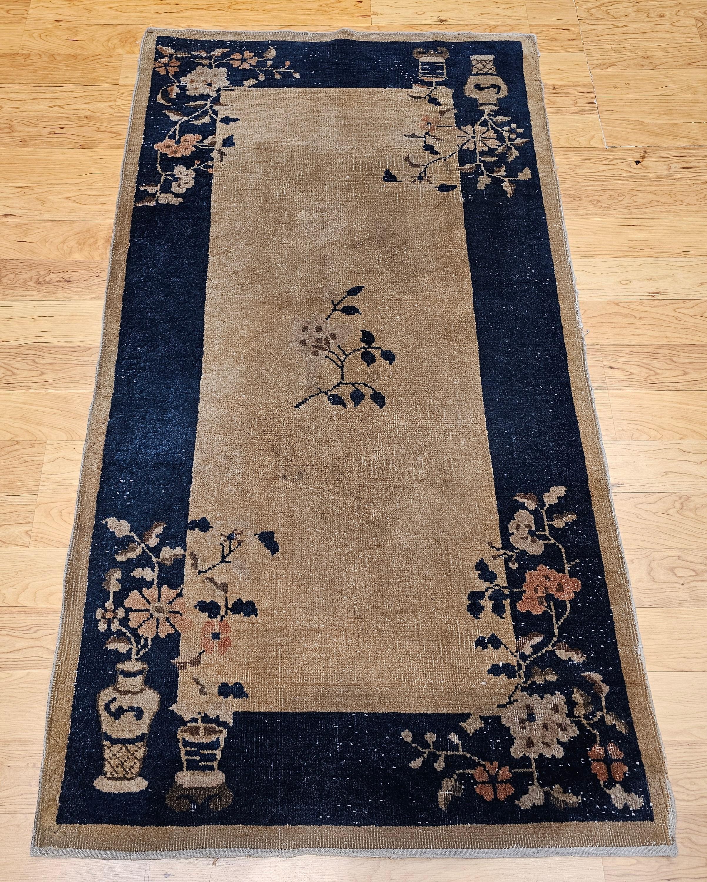 Beautiful vintage Art Deco Chinese area rug with vase pattern design in a tan color background and a navy blue border.  There is a small flower design in the center of the rug with the design of flower vases in each corner.  The Chinese Art Deco