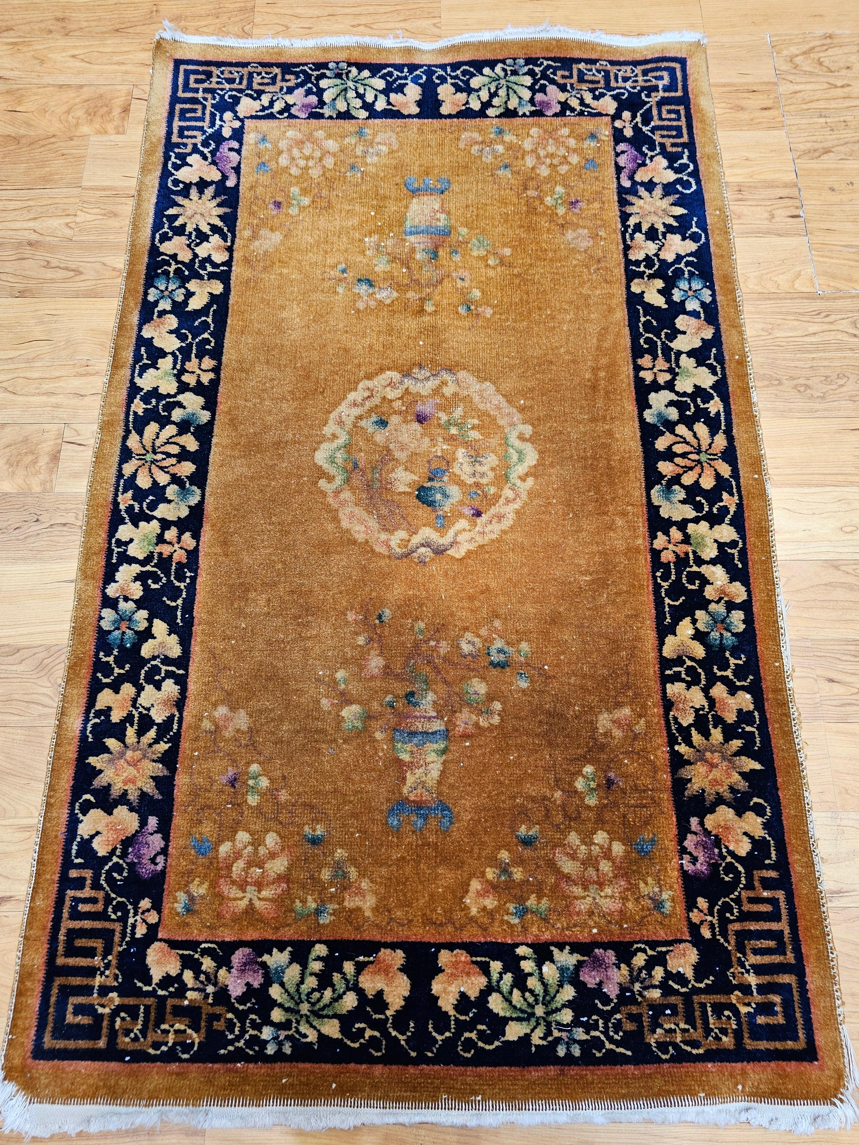 This beautiful vintage Chinese Art Deco area rug showcases the timeless elegance of early 20th-century design with a warm tan (caramel-toned) field and a contrasting dark blue border. The subtle central medallion anchors the composition, while two