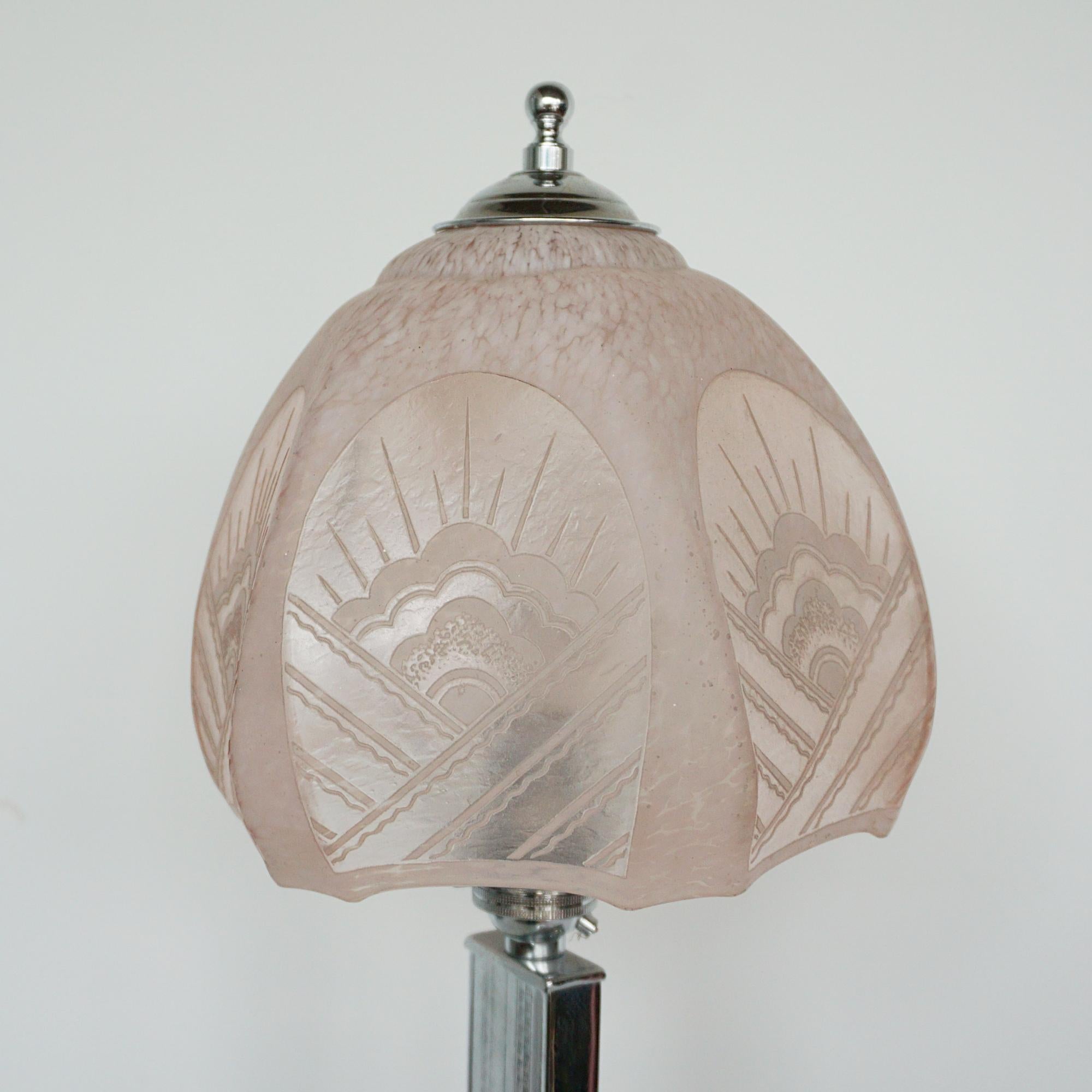 Lampe de table Art déco. Tige et base en métal chromé avec un abat-jour en forme de lever de soleil rose. Finale chromée sur le dessus. 