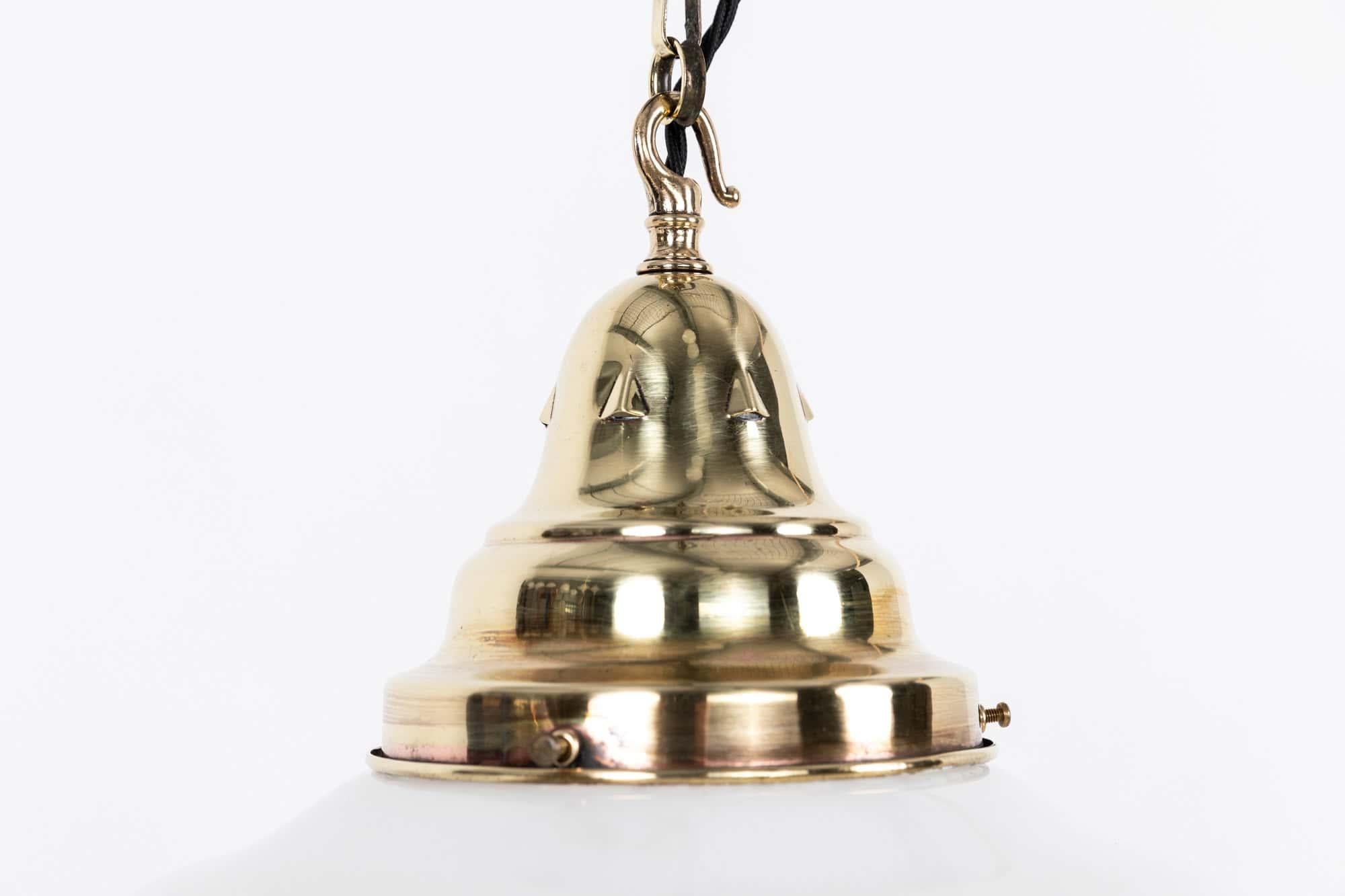 An elegant church opaline glass pendant light with brass gallery. c.1930

Moulded opaline glass shade, this shape of lamp were often found in churches and chapels up and down the country. Complete with original polished brass gallery and short