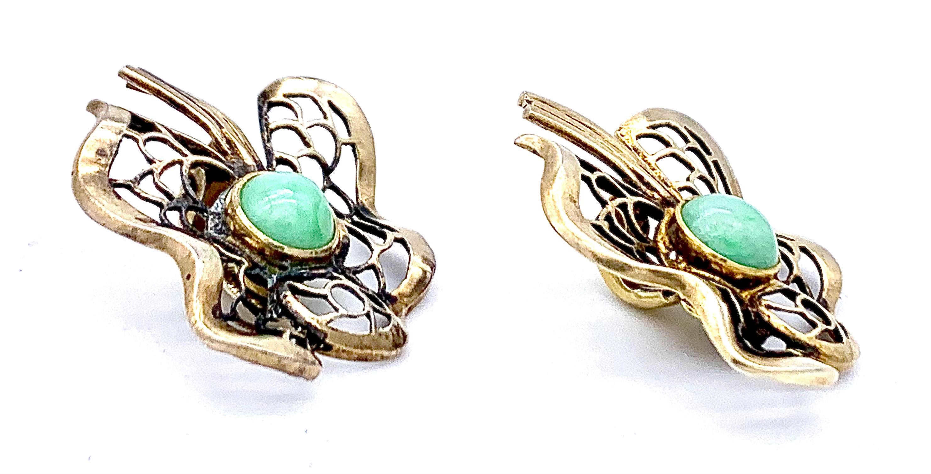 This charming pair of Art Deco earrings is designed as leaves with a ribbon and decorated with a jade cabochon.