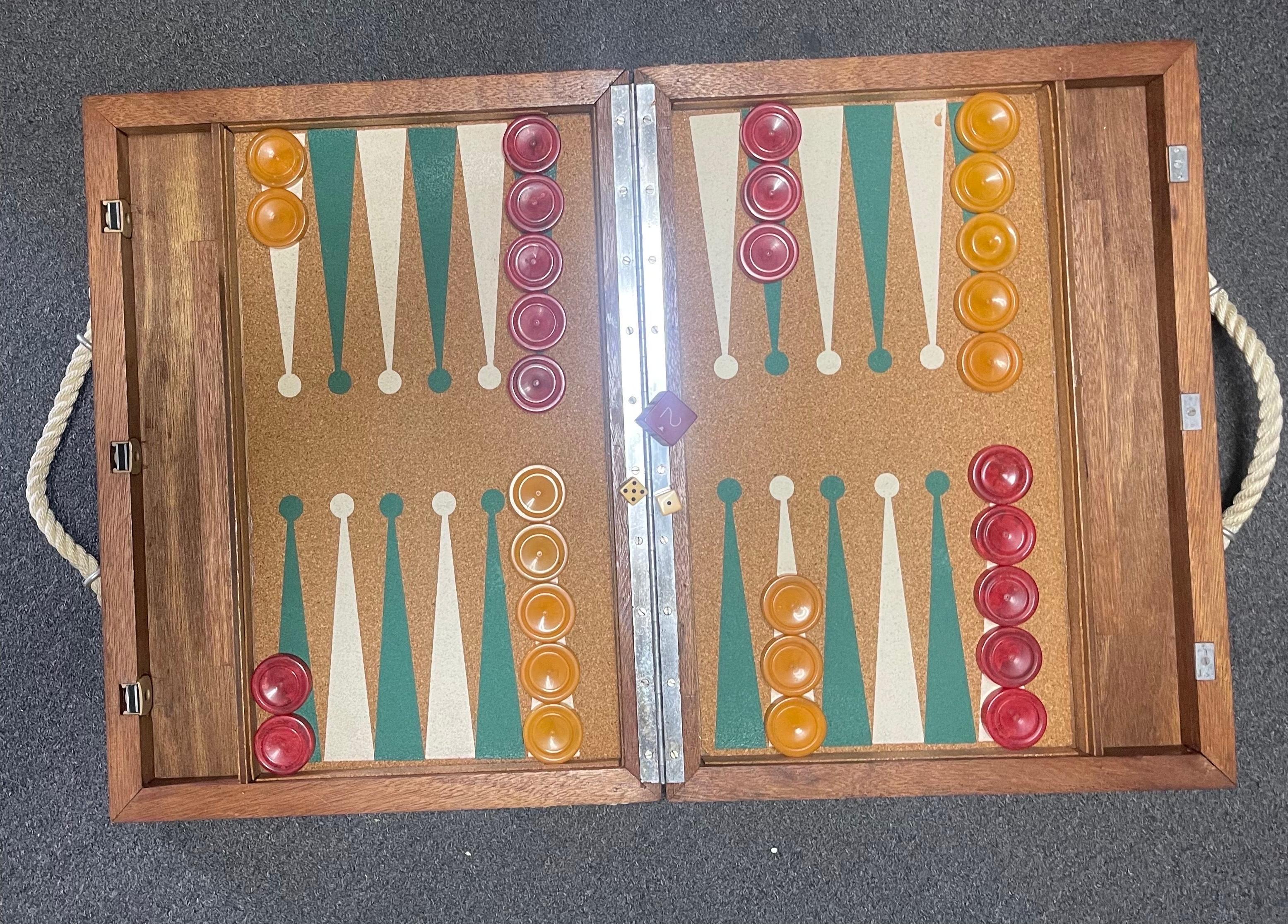 Vintage Art Deco cork and bakelite backgammon set, circa 1940s. Set is complete with a foldable wood board with cork inset, 30 bakelite checkers, doubling cube and a pair of dice. The set is in good vintage condition and the board measures 21