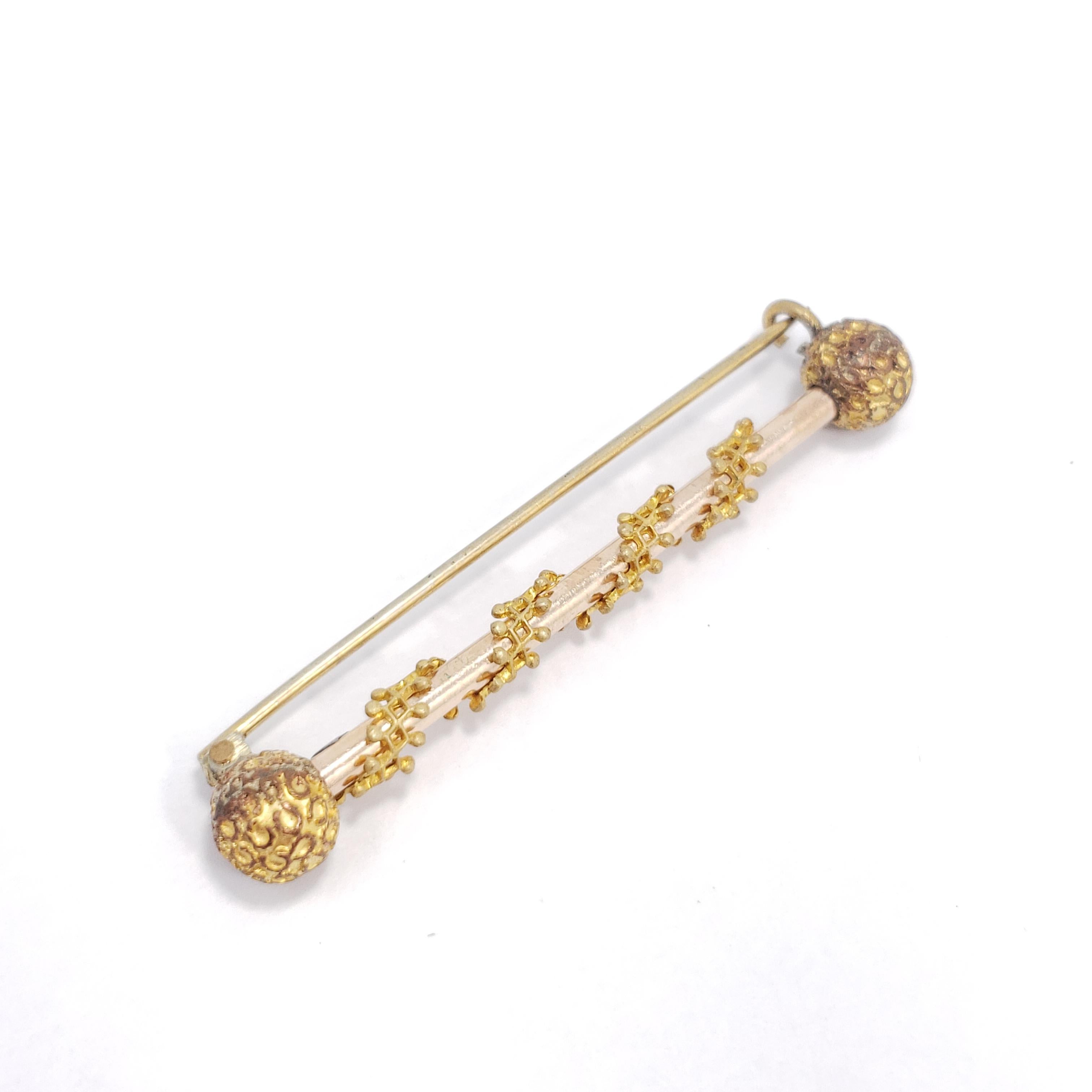 Stylish, vintage art-deco accessory. This golden bar brooch features decorative accents for a sophisticated touch.

Early 1900s open clasp closure. Gold-tone.