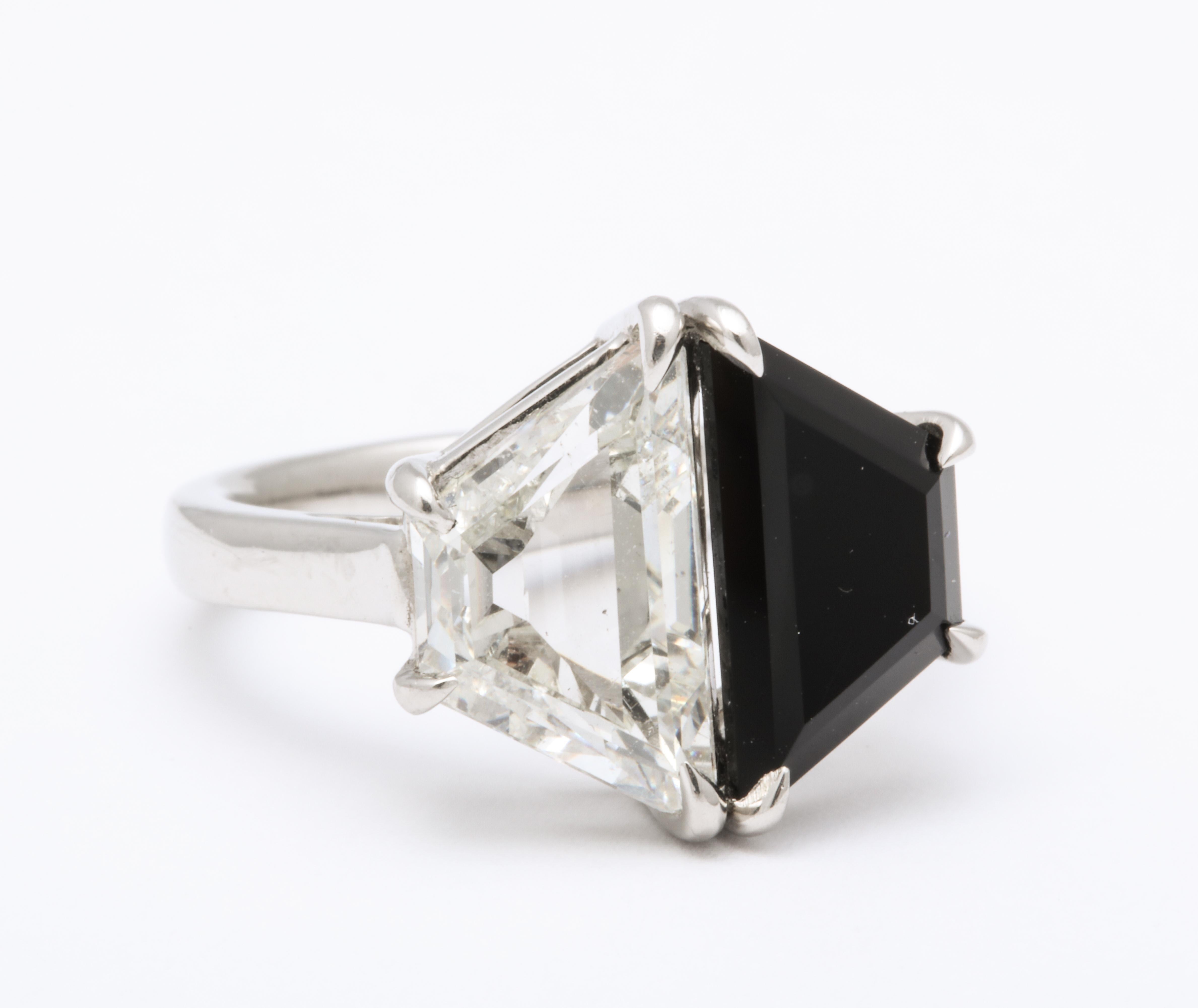 A stunning rare Art Deco Design trapezoid 2.75 ct cut diamond and onyx vintage ring set in a classic original platinum band.  Diamond VS H color.  This is a rare cut and exceptional size to  find in a vintage ring and black and white is most