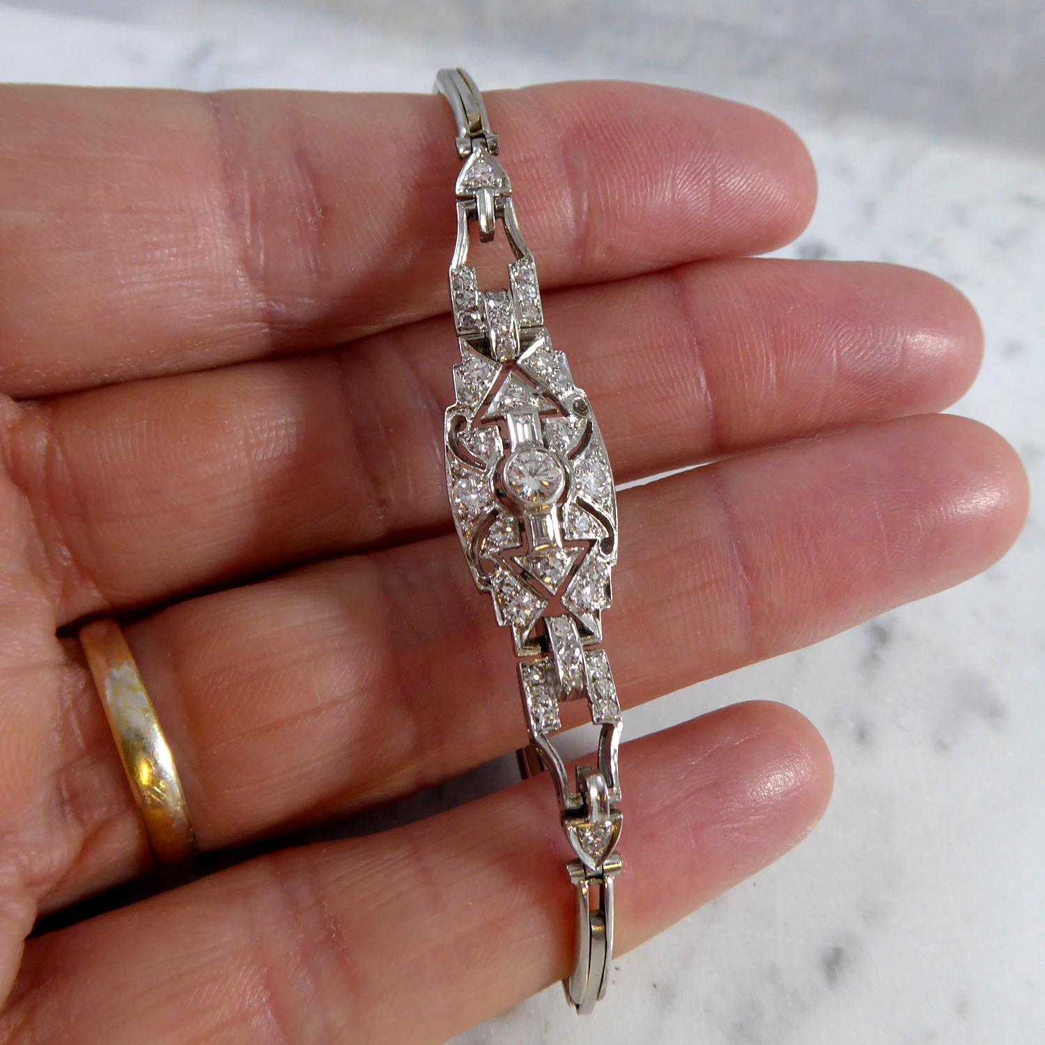 A diamond set bracelet from circa 1930s/1940s.  Consisting of an openwork navette panel rub-over set to the centre with an early brilliant cut diamond against a diamond accented background (details blow).  The diamond set panel is attached at each