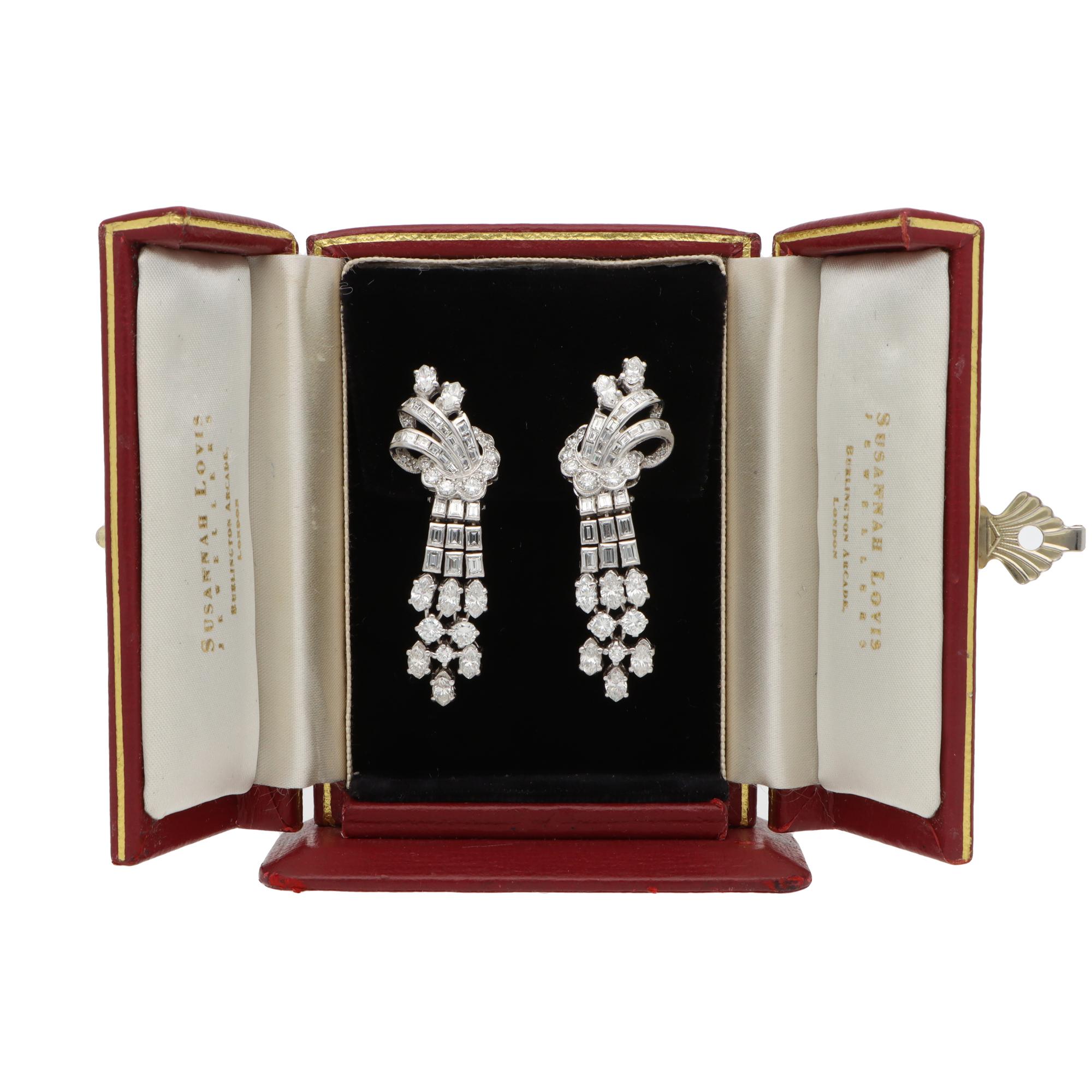 A truly stunning pair of vintage Art Deco diamond drop earrings set in platinum, circa 1930s.

These earrings are beautifully handcrafted and each prominently feature an abstract knot and spray effect design.

Within each earring the main body is