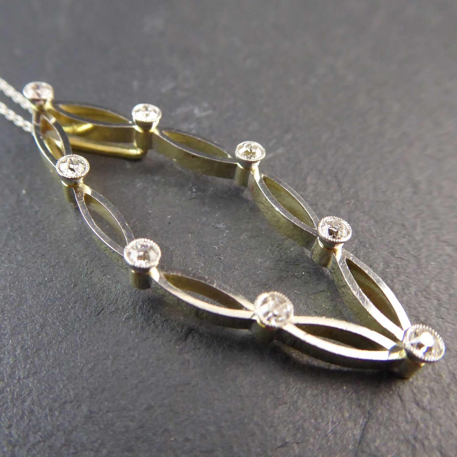 An elegant art deco diamond pendant dating from circa 1930s.  Fashioned in an open overall marquise shape comprising smaller marquise shaped open links, each link connected by a collar set, millegrain edge, brilliant cut diamond each approx. 0.025ct