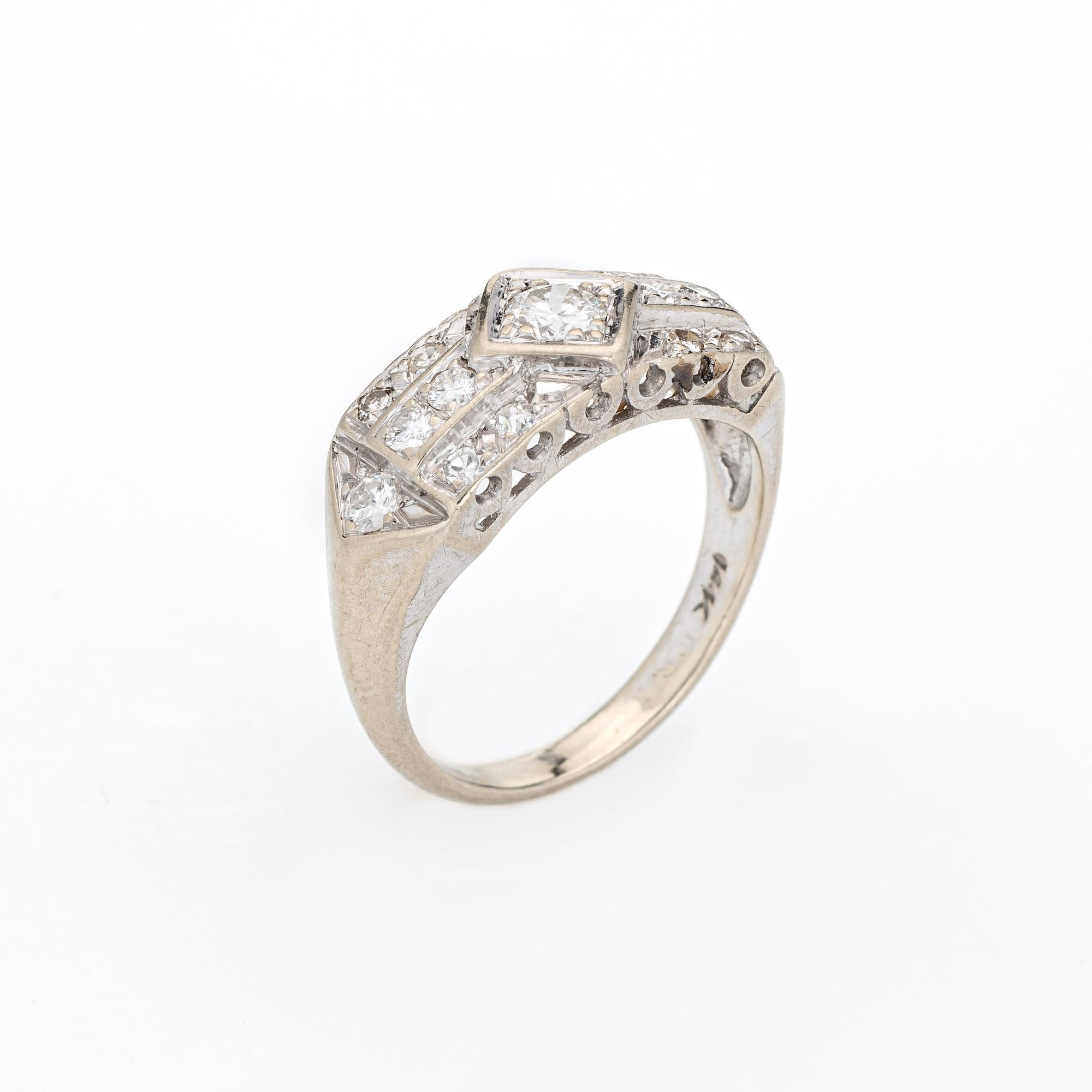 Finely detailed vintage Art Deco diamond wedding band (circa 1920s to 1930s) crafted in 14 karat white gold. 

Centrally mounted estimated 0.20 carat old European cut diamond is accented with a further 14 estimated 0.02 to 0.04 carat diamonds. The