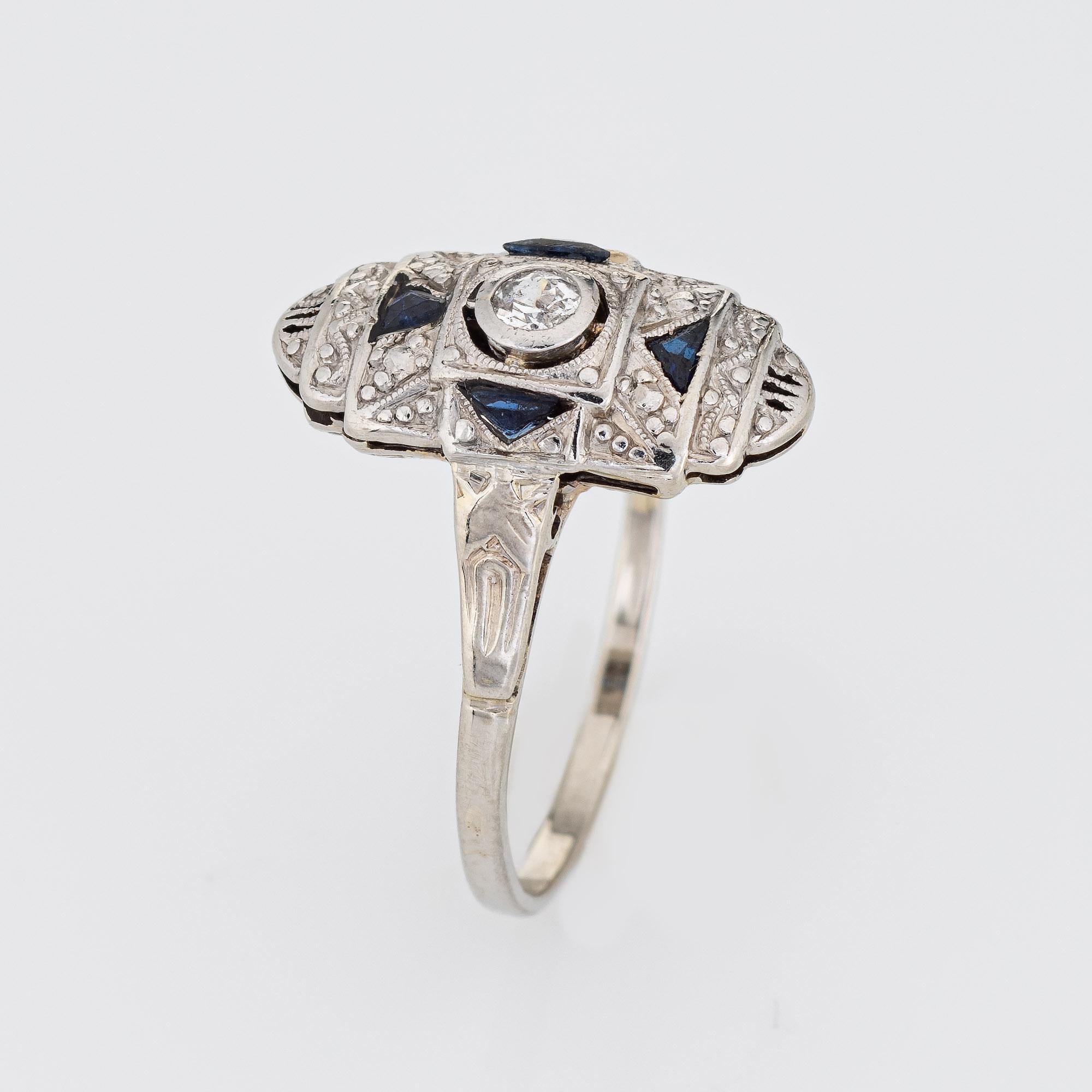 Finely detailed vintage Art Deco diamond & sapphire ring (circa 1920s to 1930s) crafted in 14k white gold. 

One estimated 0.10 carat old European cut diamonds is estimated at J-K color and I1 clarity. Four sapphires (lab) total an estimated 0.15