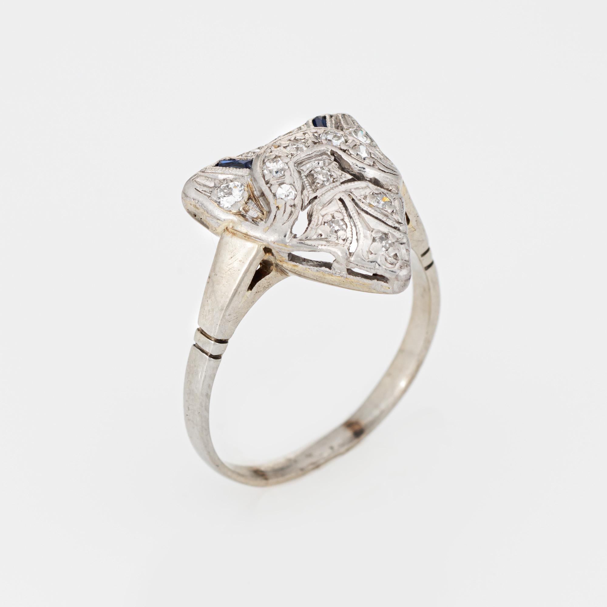Bague vintage Art Deco finement détaillée en diamant et saphir synthétique (circa 1920 to 1930s), réalisée en or blanc 14k.  

13 diamants taille unique d'une valeur totale estimée à 0,06 carat (couleur I-J et pureté SI2-I2). Deux saphirs