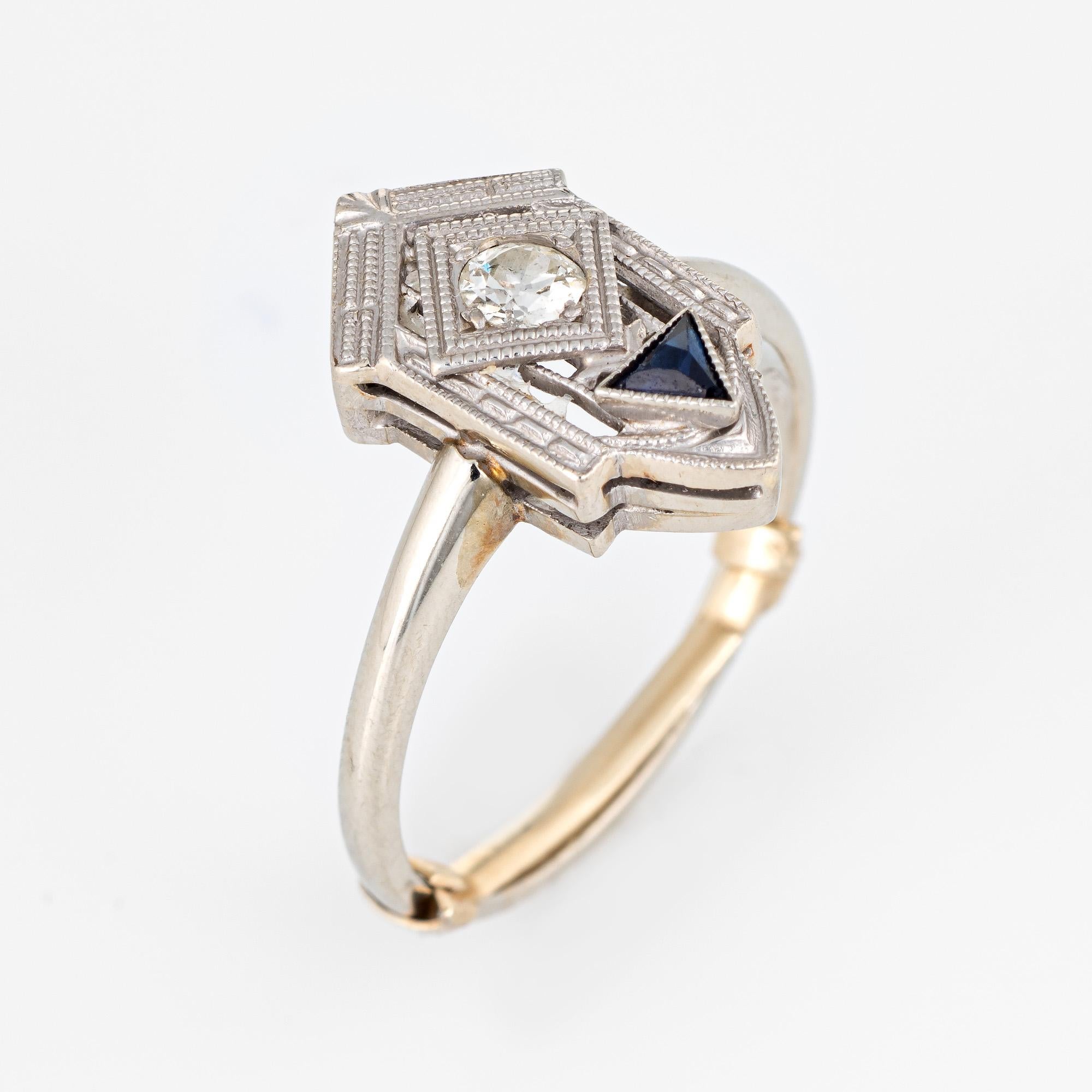 Elegant vintage Art Deco era ring (circa 1920s to 1930s) crafted in 18 karat white gold. 

Centrally mounted old European cut diamond is estimated at 0.15 carats (estimated at H-I color and SI2 clarity). The French cut triangular sapphire is