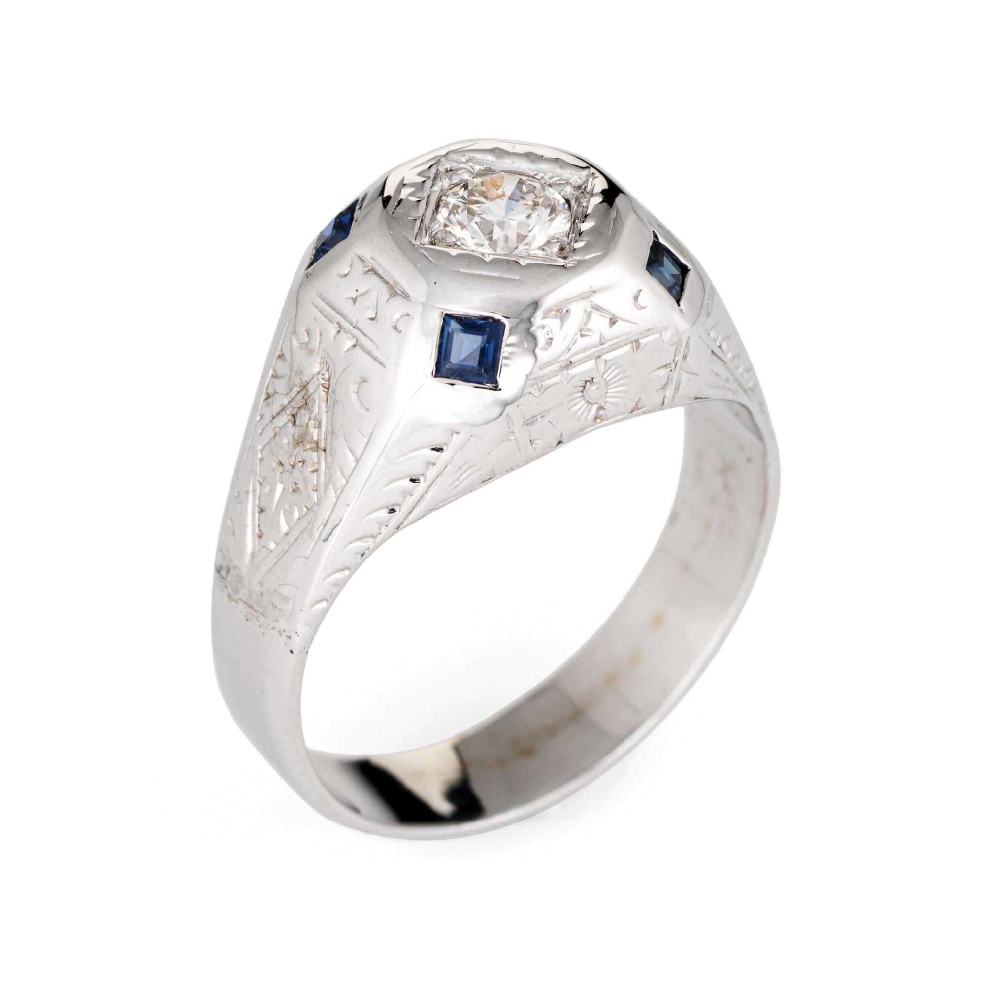 Finely detailed vintage Art Deco era ring (circa 1920s to 1930s) crafted in 14 karat white gold. 

Centrally mounted estimated 0.35 carat old European cut diamond (estimated at I-J color and SI2 clarity). Four square cut sapphires are estimated at