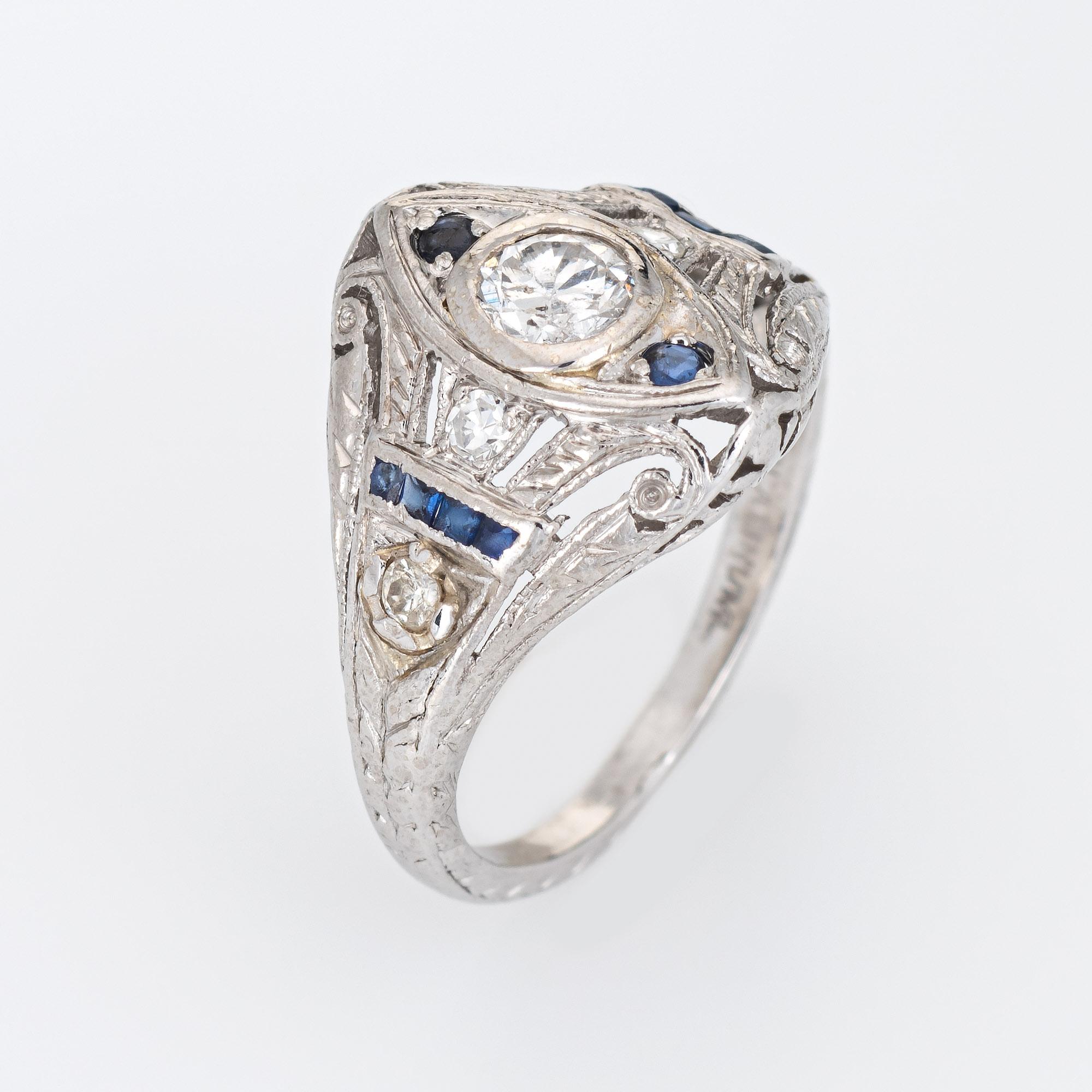 Finely detailed vintage Art Deco era diamond & sapphire ring (circa 1920s to 1930s) crafted in 900 platinum. 

Centrally mounted estimated 0.20 carat Old European cut diamond is accented with four estimated 0.01 carat single cut diamonds. The total