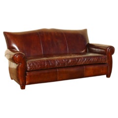 Vintage Art Deco Distressed Brown Leather Three-Seat Sofa With Mustache Back