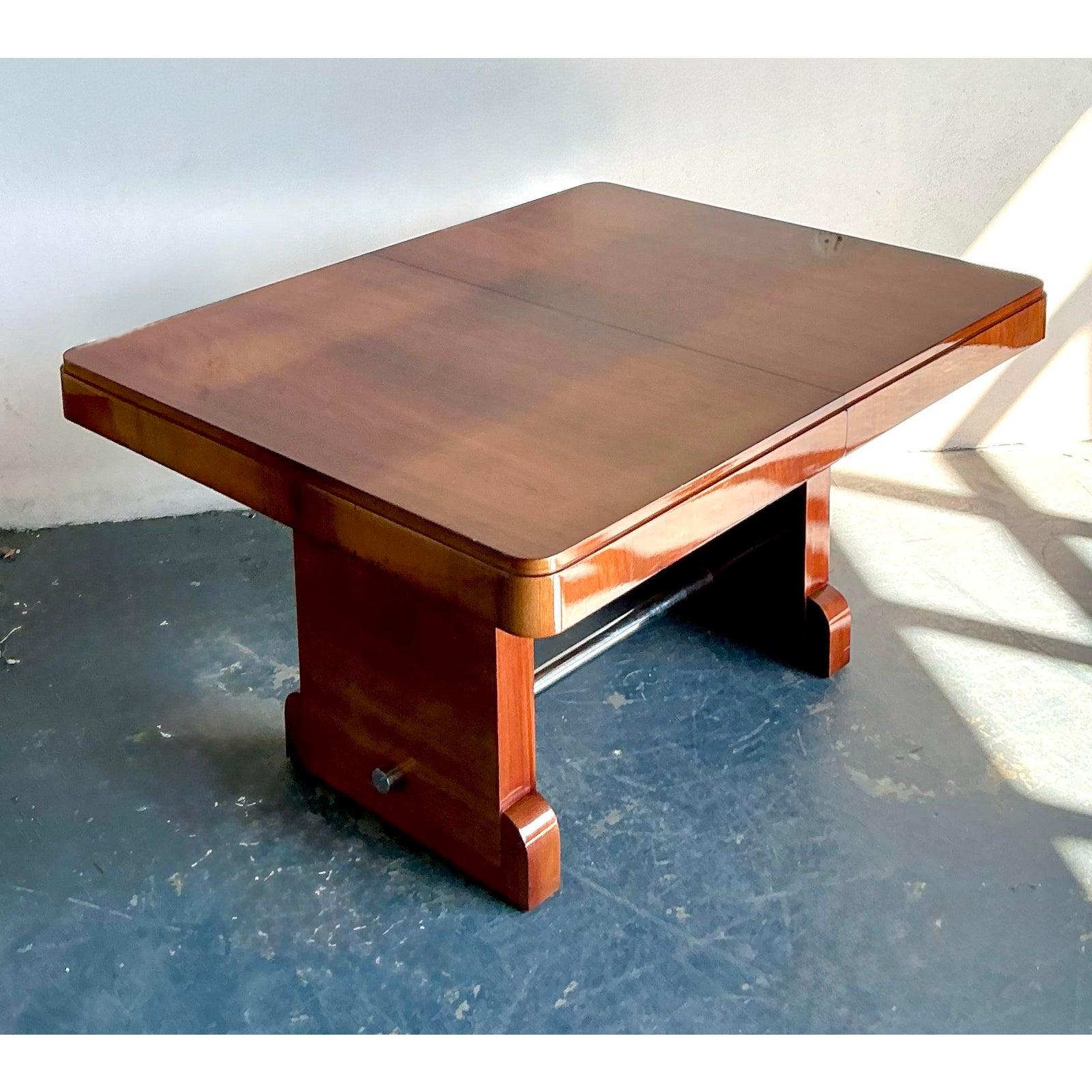 Cette impressionnante table de salle à manger reprend la sensibilité luxueuse et épurée de l'époque Art déco, avec un savoir-faire renouvelé de haute qualité. Fabriqué en placage d'acajou flammé aux tons riches et profonds ou de bois figuré