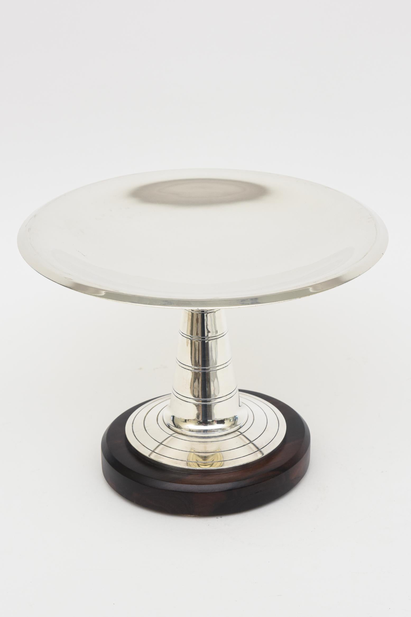 This stunning and substantial French Art Deco silver- plate and rosewood base pedestal bowl or serving piece has concentric lines at the column and top of the base before the rosewood base. It was acquired by us in Paris 25 years ago and has