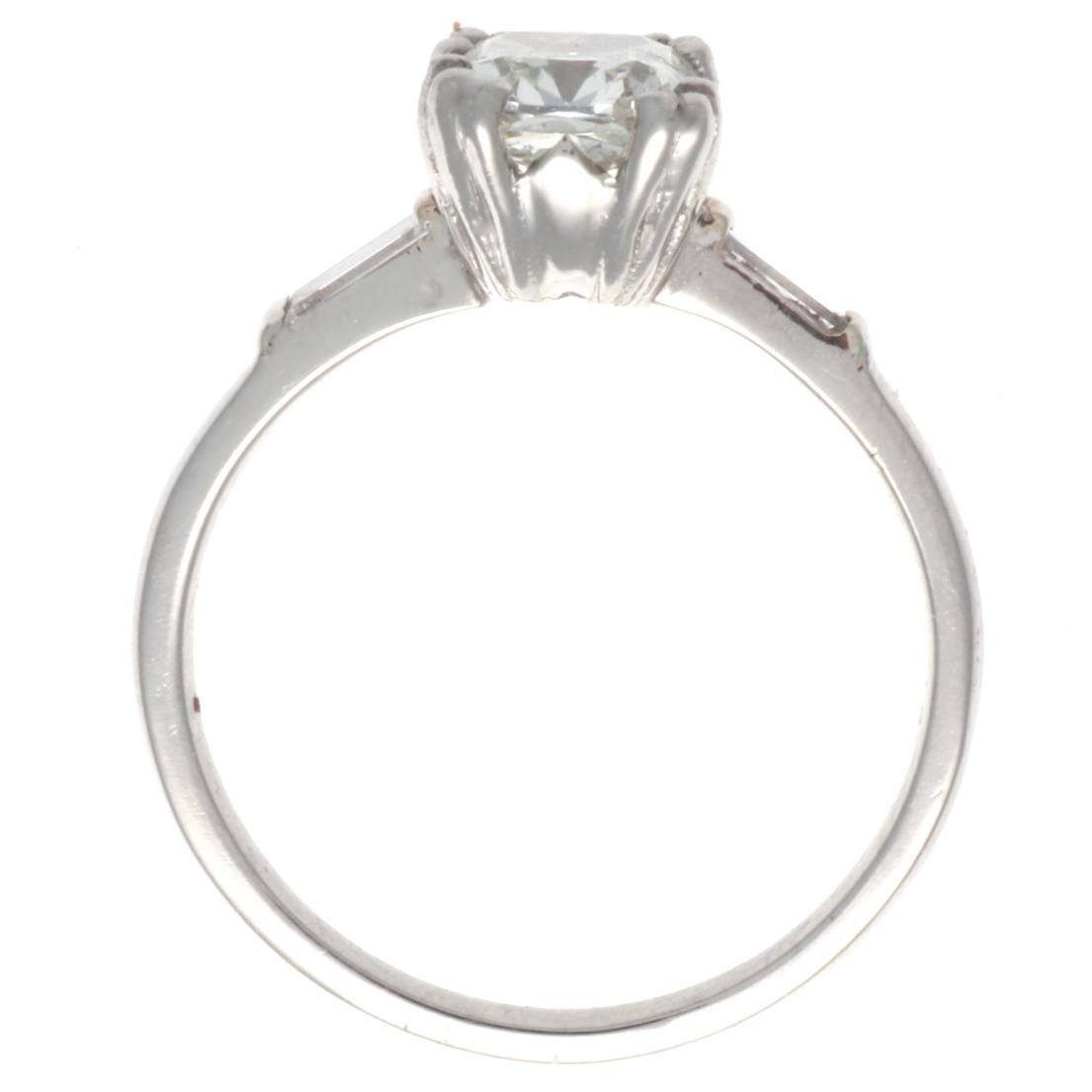 This perfectly poised Art Deco diamond engagement ring features a GIA certified 1.26 carat, K color VVS1 old mine cut diamond. Crafted in platinum, it includes 2 baguette cut diamonds that weigh approximately 0.20 carats, graded F-G color, VS-SI
